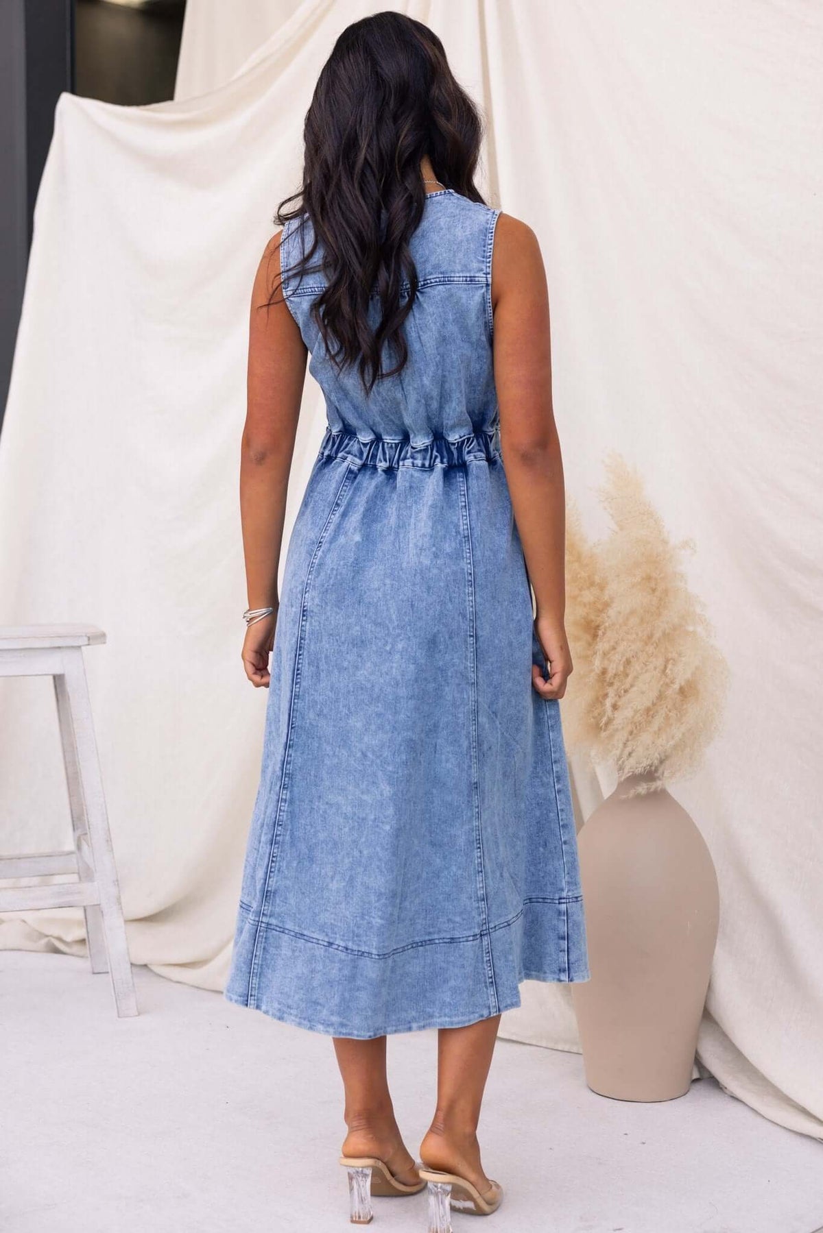 Back view of the Kerrie Denim Midi Dress, showcasing the elastic waist and flowing hem in light blue denim.