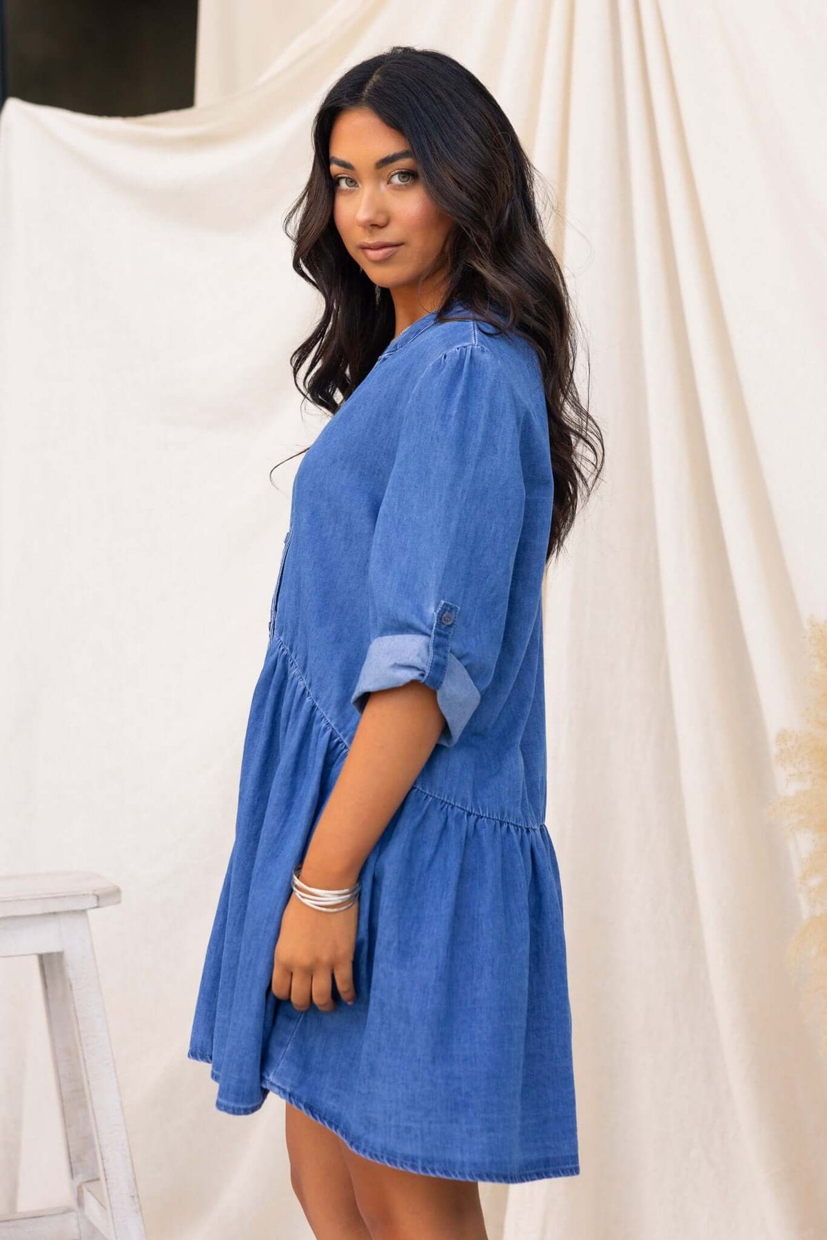 Model wearing a Gracie Denim Dress with V-neckline and button-up front in relaxed fit, showcasing denim fabric.