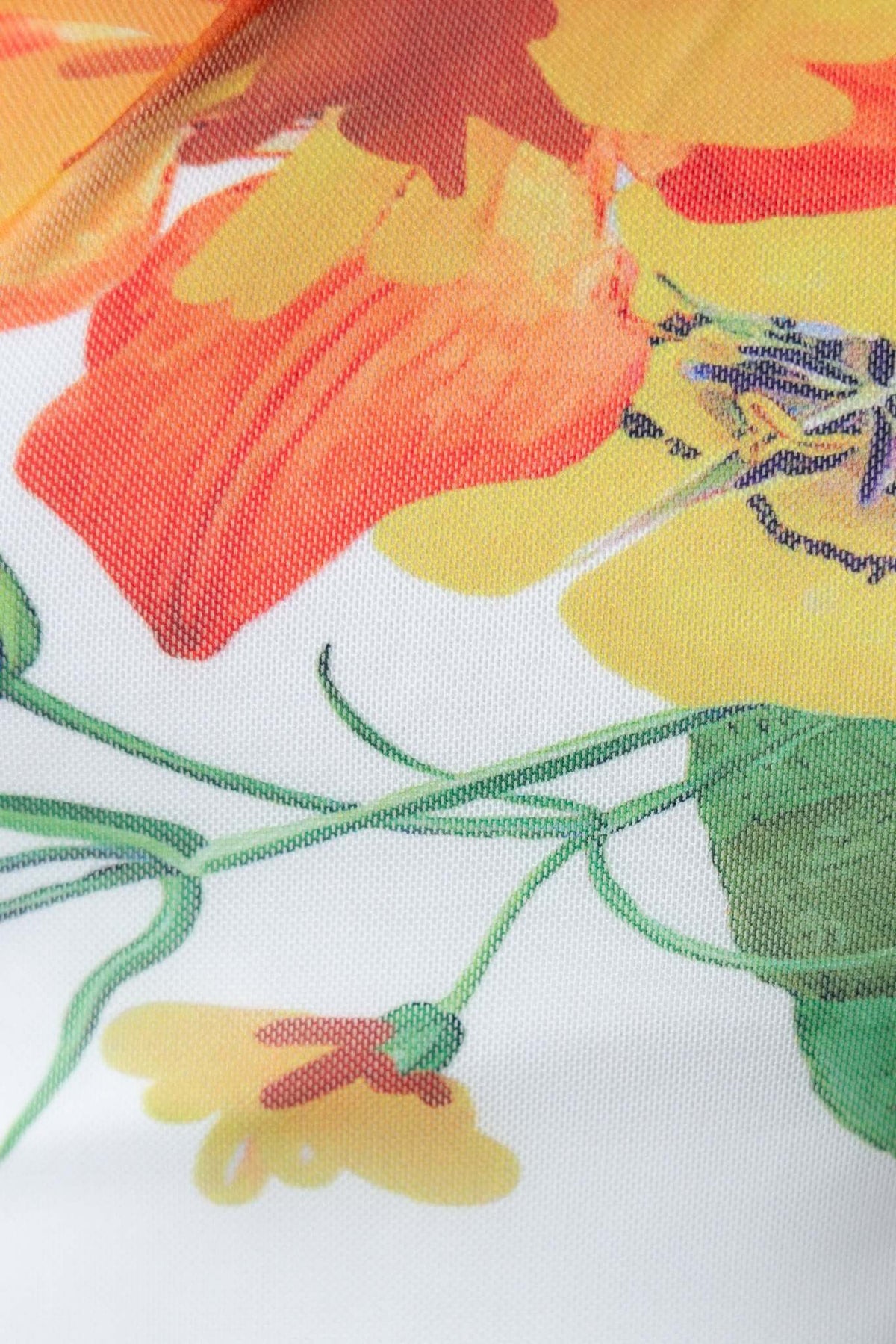 Close-up of vibrant floral pattern featuring orange and yellow flowers on lightweight fabric.