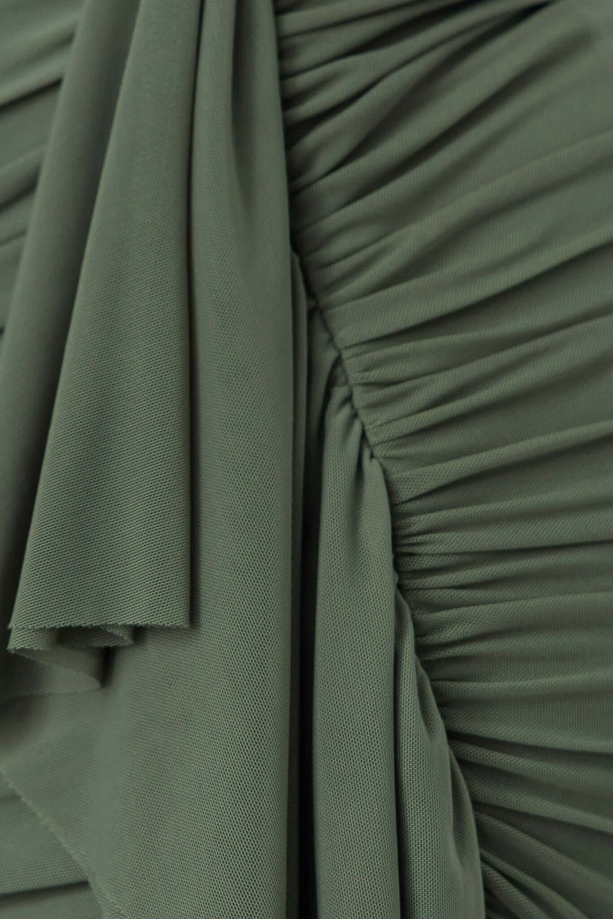 Close-up of green fabric with ruched detailing, showcasing texture and draping style for Iroha Maxi Dress.