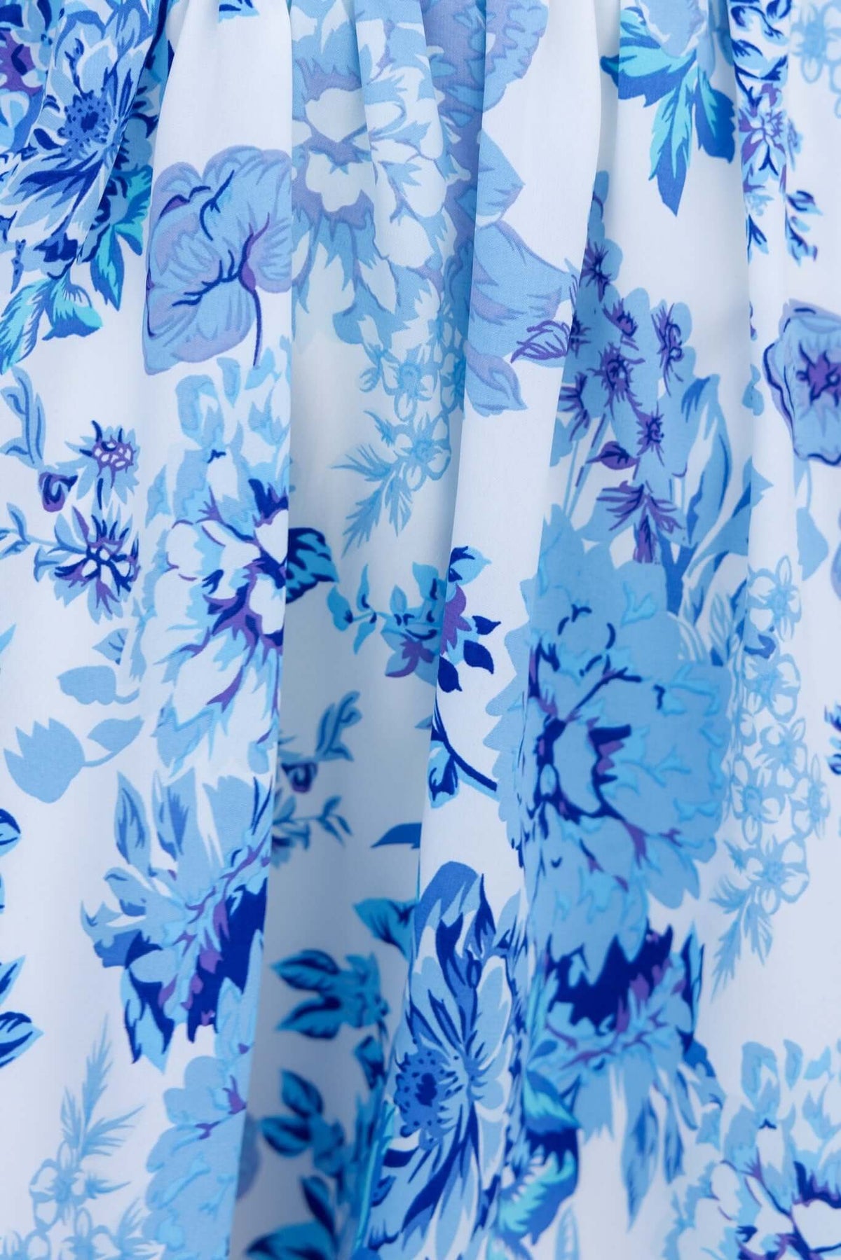 Close-up of floral fabric in shades of blue, showcasing a stylish pattern suitable for summer dresses.