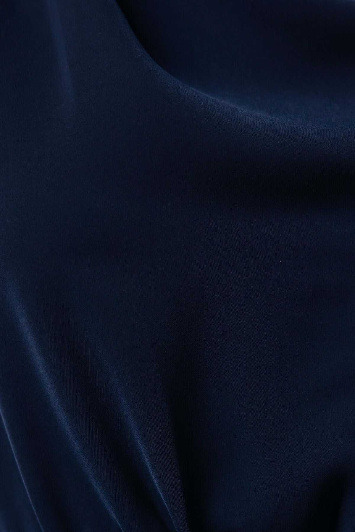 Close-up of navy fabric texture of Sedalia Midi Dress, showcasing its smooth and luxurious polyester material.