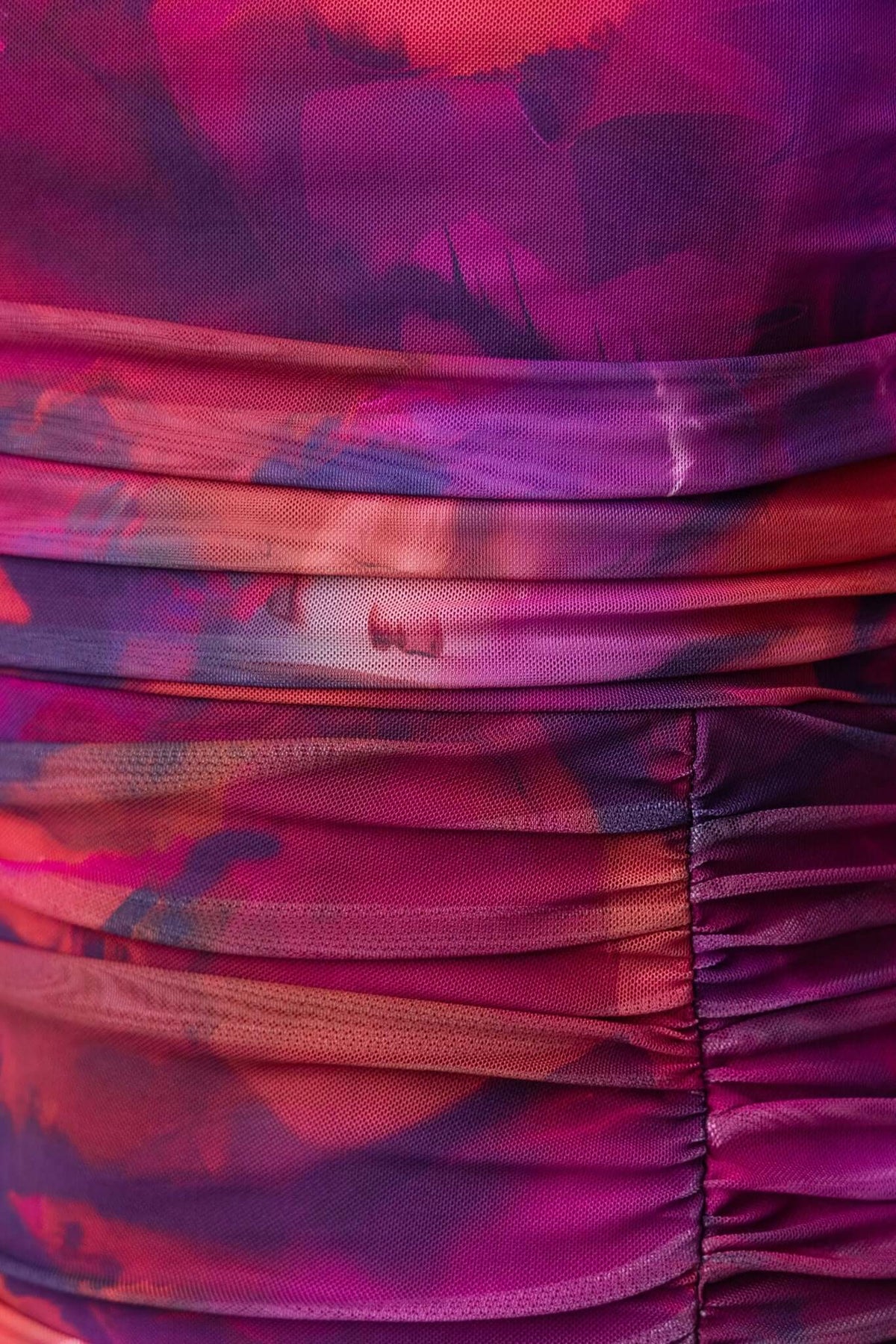 Close-up of vibrant pink and purple ruched fabric, showcasing texture and color blending for the Breslin Maxi Dress.