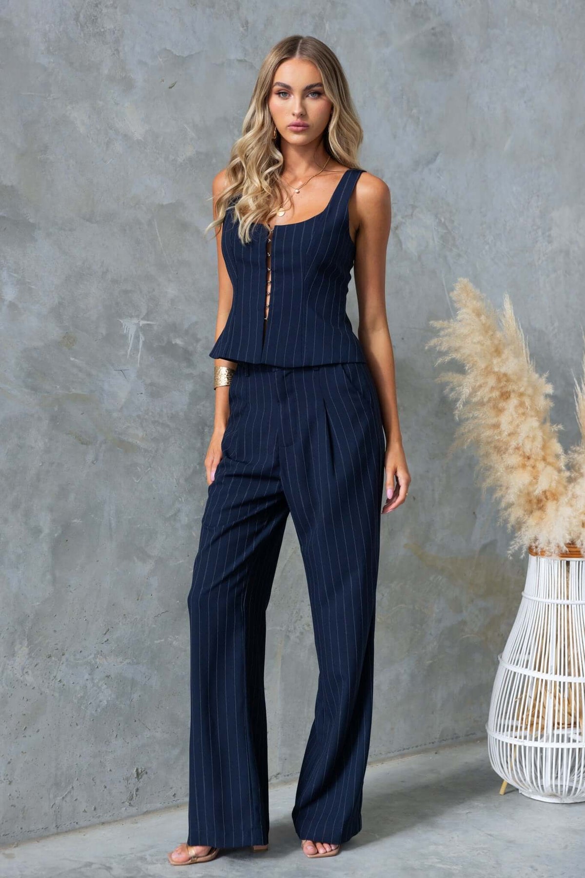 Model wearing Renton Pants with a matching top, featuring a mid-high waist and navy pinstripe design.