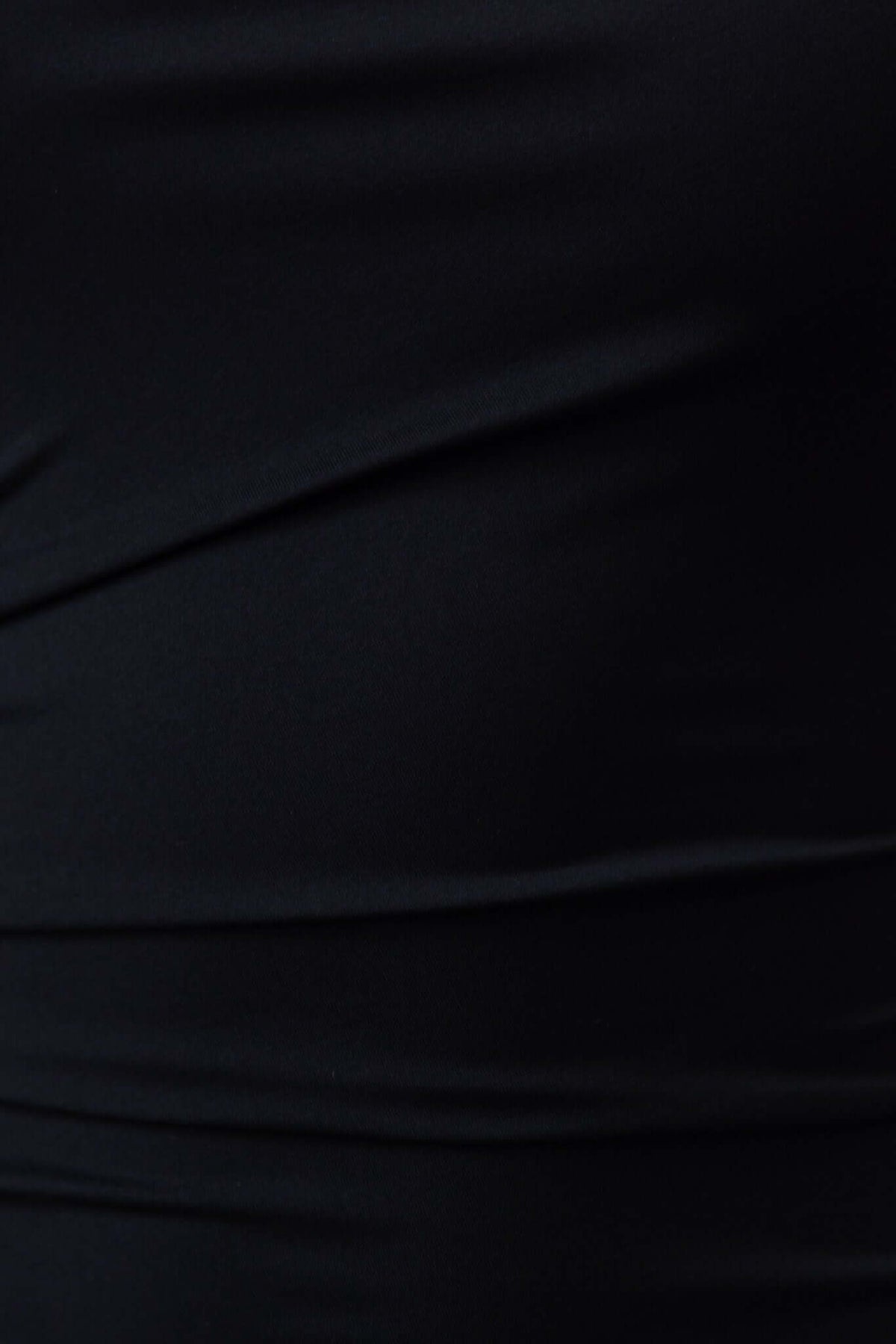 Close-up of black fabric showcasing the stretch and texture of the Glory Maxi Dress's material.