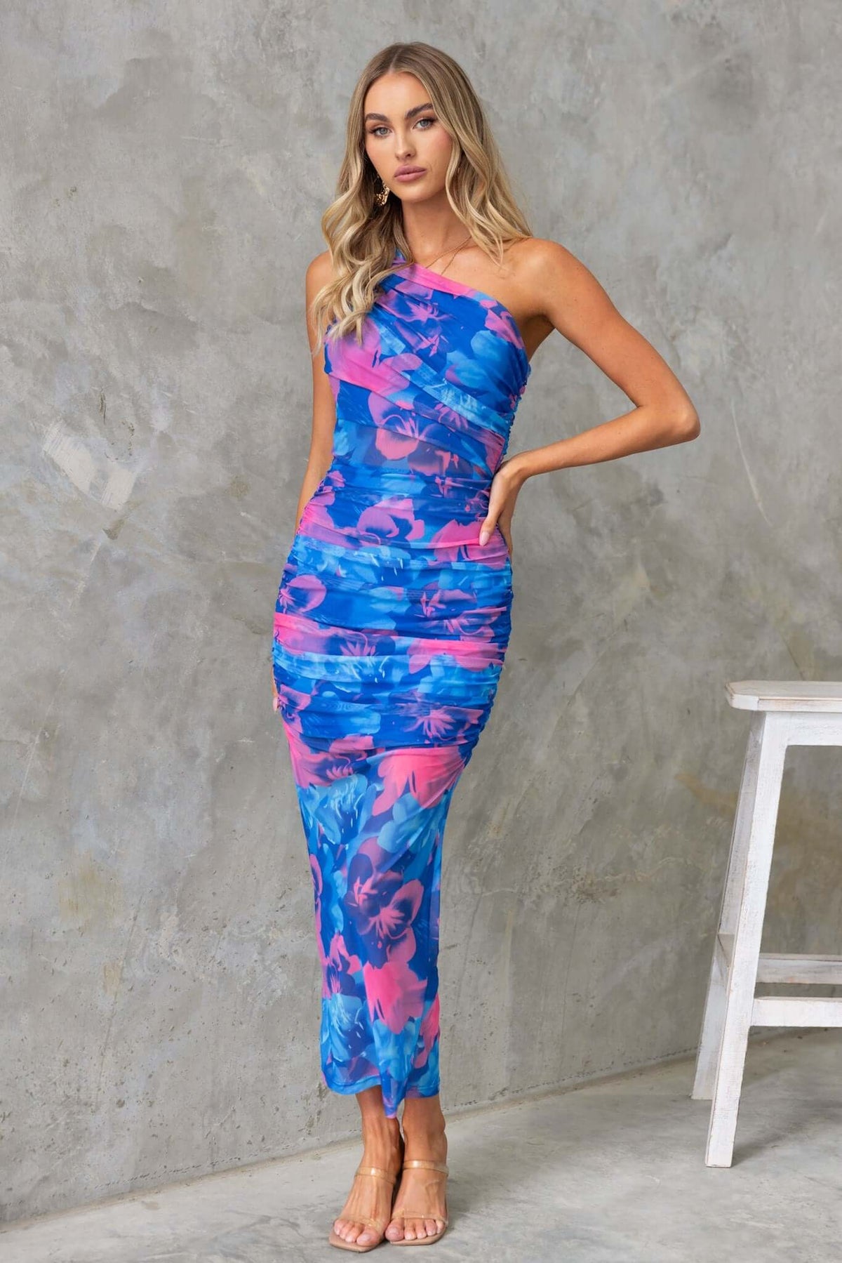Sundara Maxi Dress with one-shoulder neckline, vibrant blue and pink pattern, featuring a fitted style and mesh overlay.