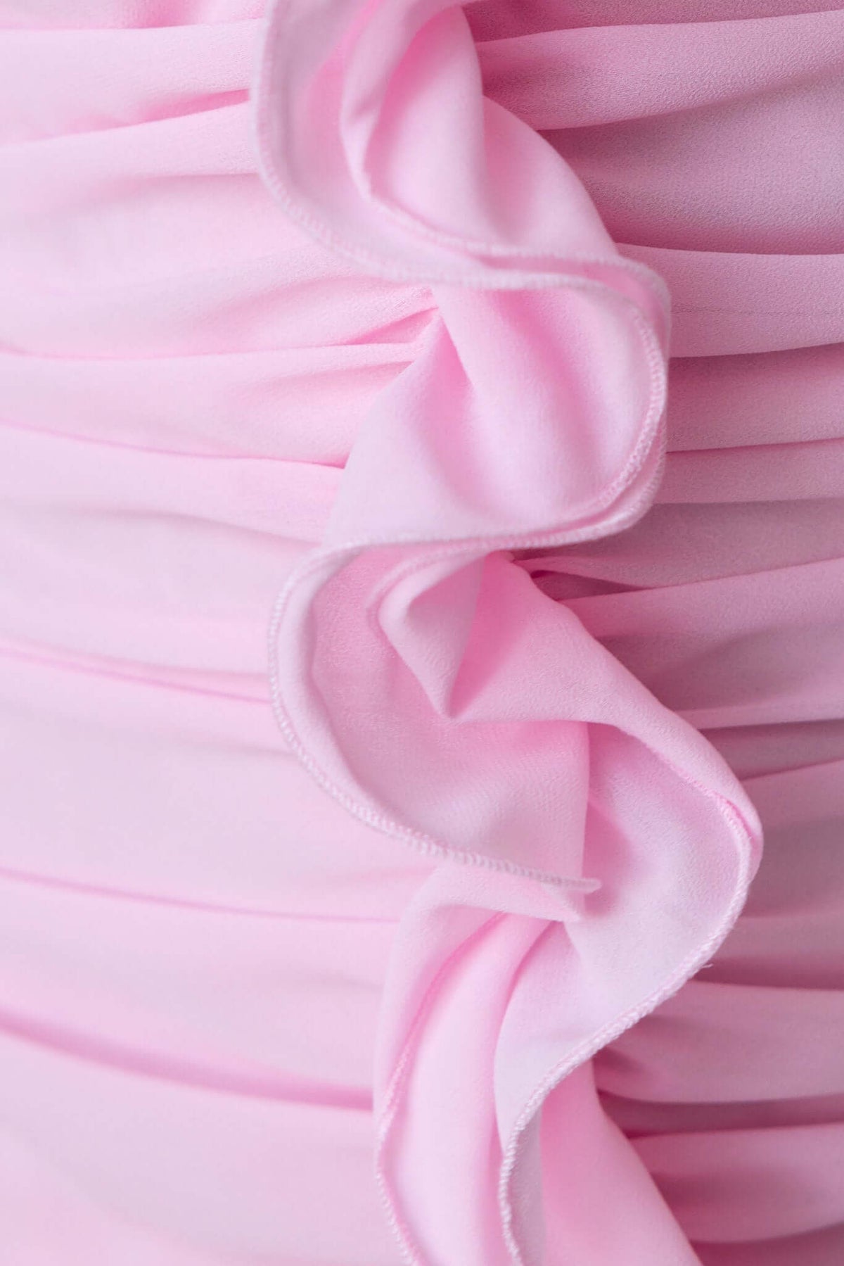 Close-up of pink ruffle detail on the Jadore dress, showcasing soft chiffon fabric and elegant design.