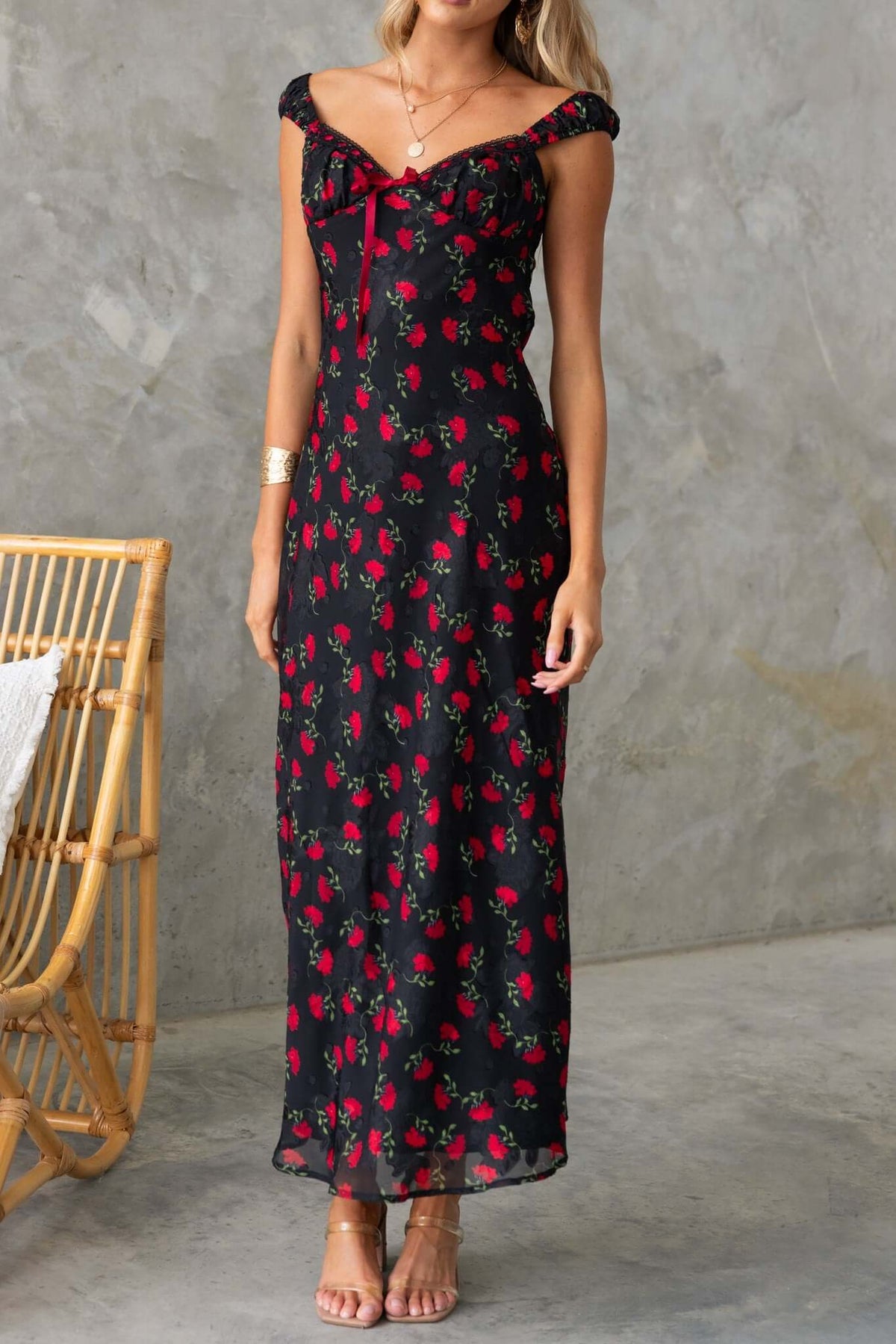 Parma Maxi Dress featuring a black floral design, off-shoulder sleeves, and a fitted silhouette for a summer look.