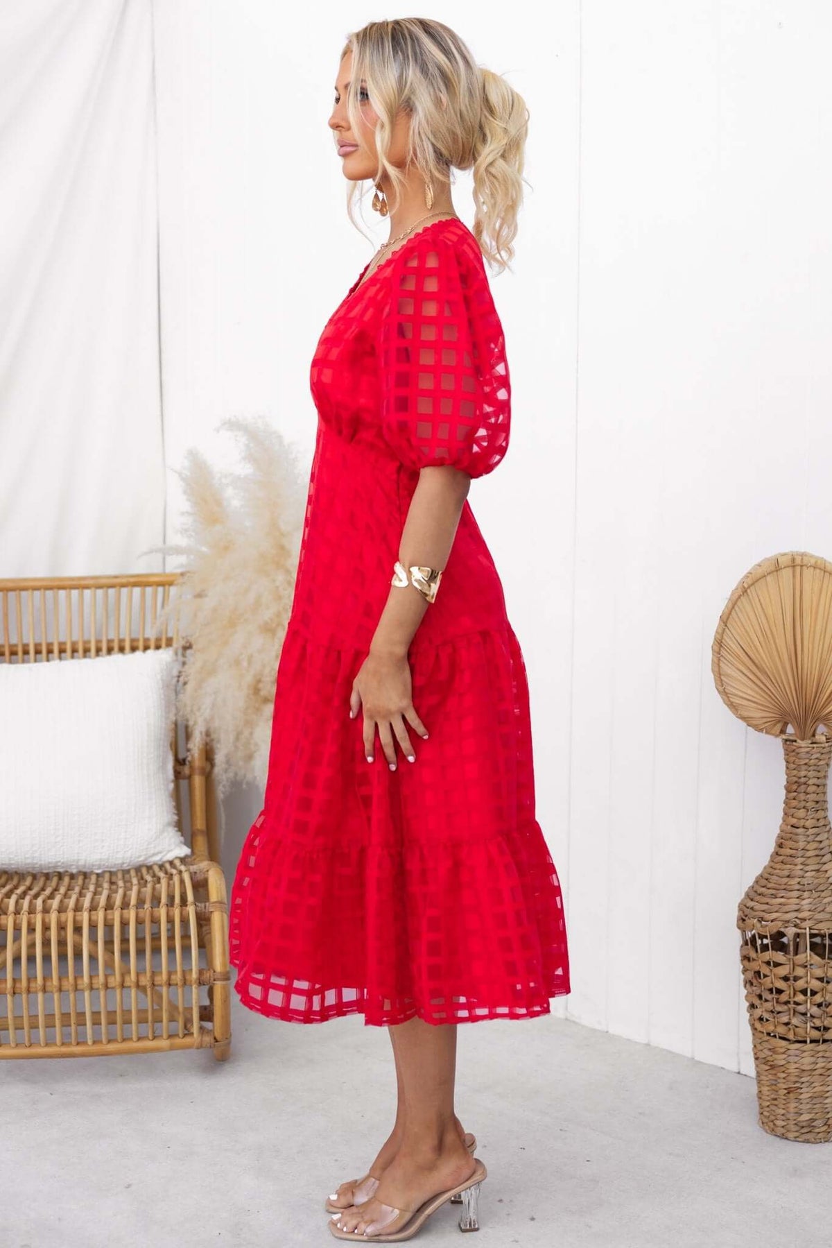Barker Midi Dress in red featuring puff sleeves, shirred back, and tiered skirt, styled with elegant accessories.