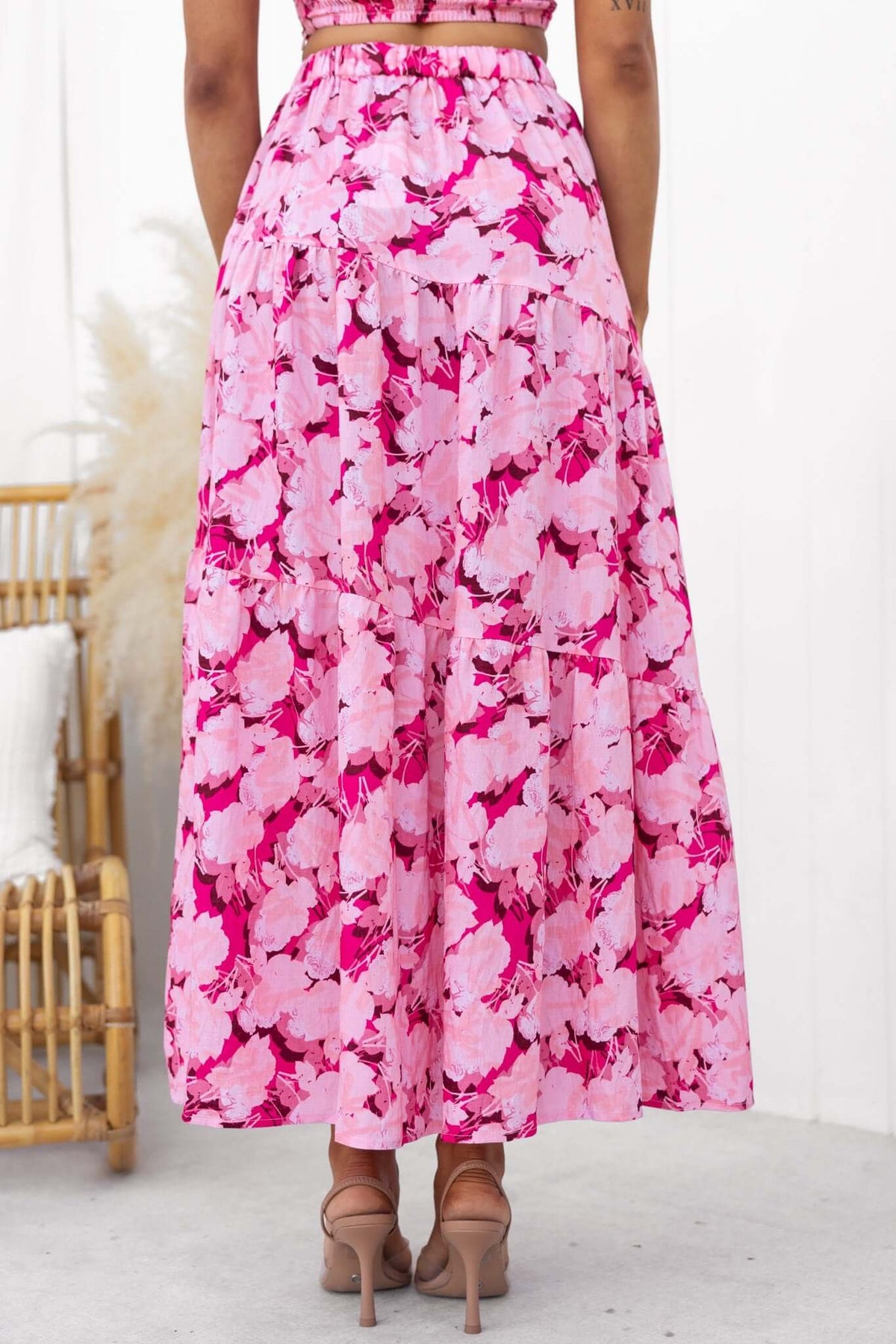 Back view of a Peachy Days Maxi Skirt featuring a vibrant pink floral pattern and elastic back waist.