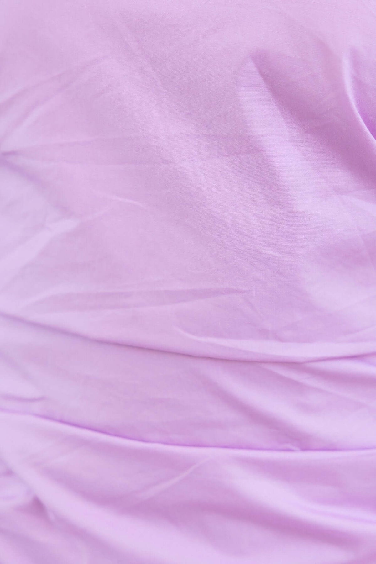 Close-up of soft, lilac fabric showing texture and wrinkles, perfect for Ricket Mini Dress styling.