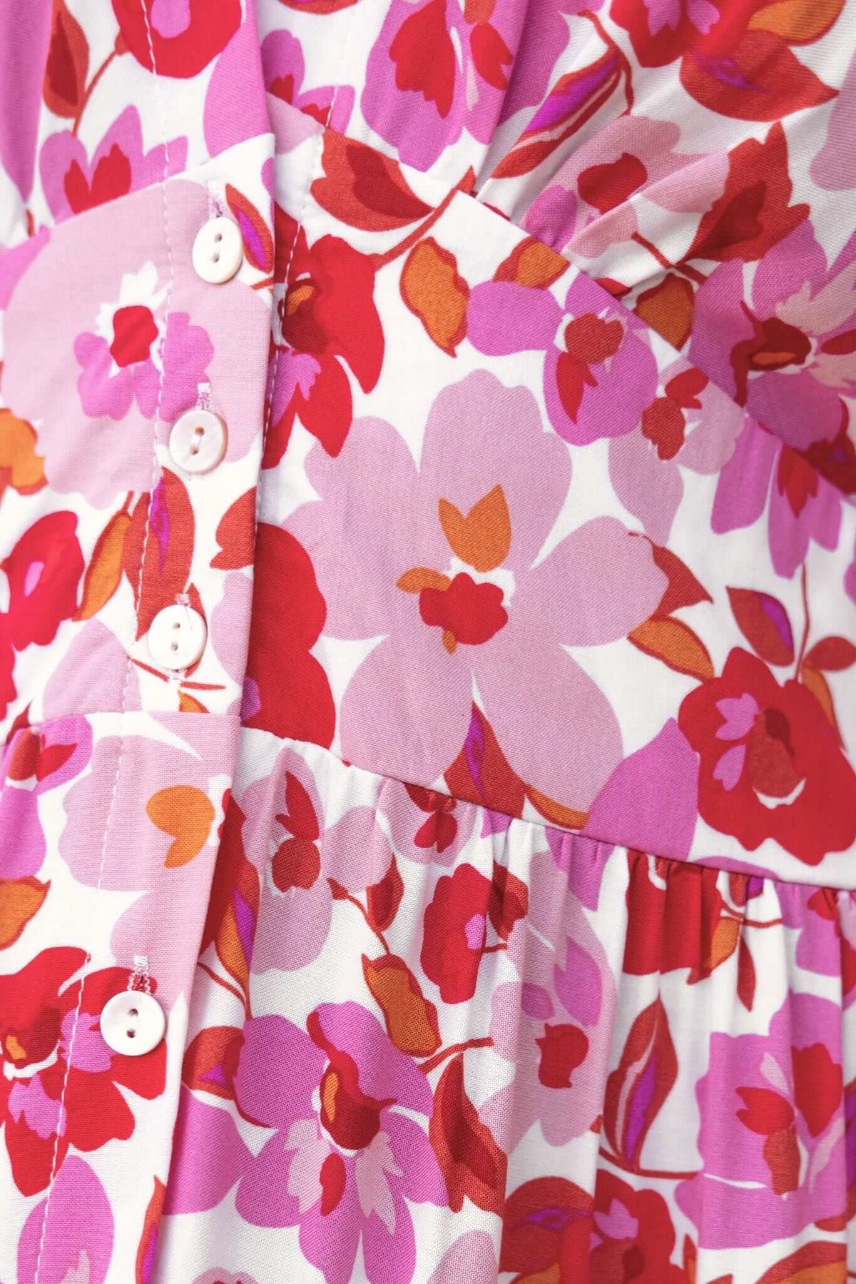 Close-up of Hope Filled Midi Dress with colorful floral pattern, button front, and shirred elastic panel at back.