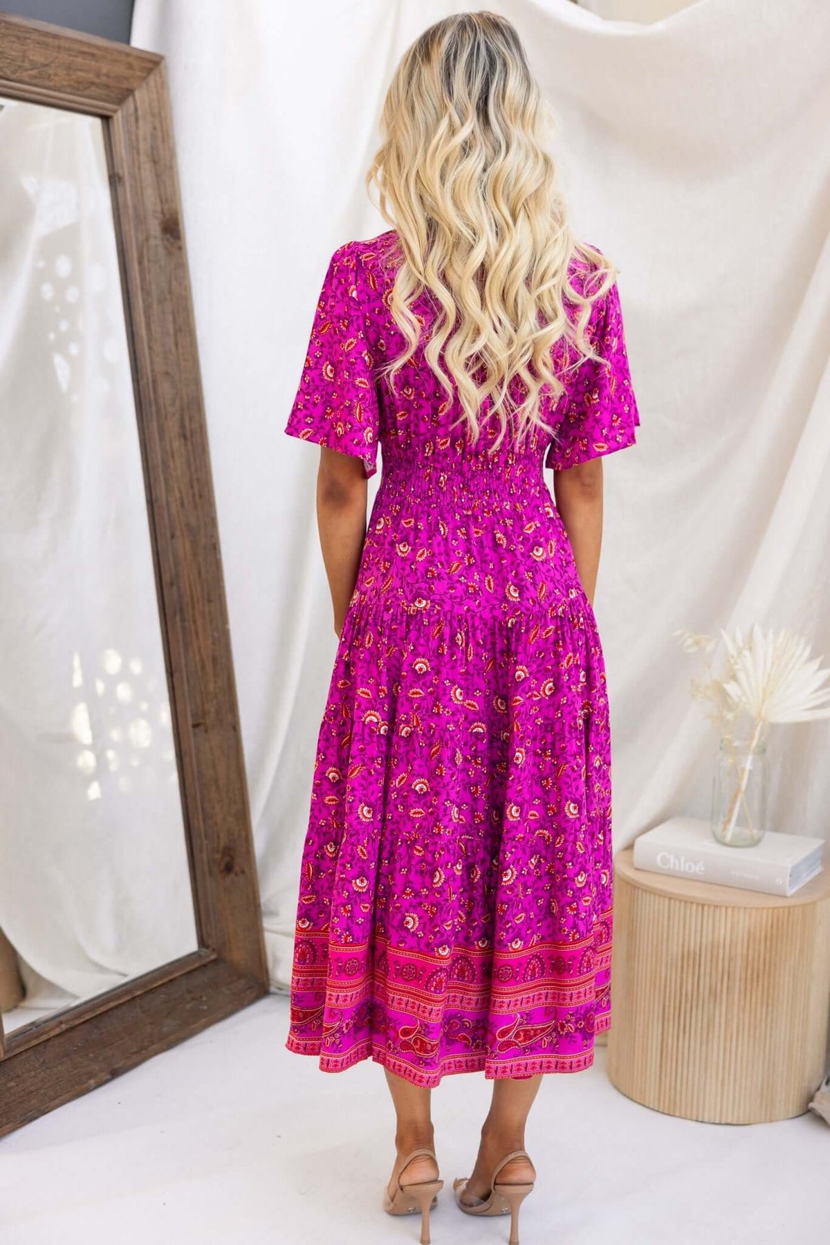 Hope filled Midi Dress in vibrant pink floral print, featuring a shirred elastic waist and short sleeves, styled for a classic look.