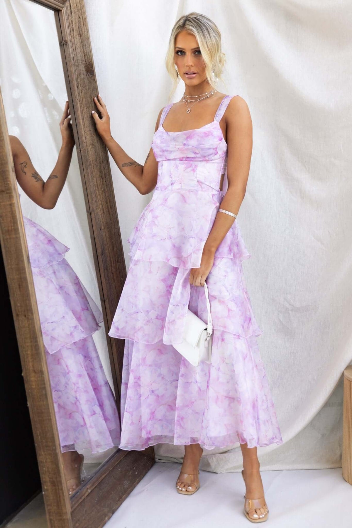 Model wearing a lavender Bennett Ave Maxi Dress with tiered frills, alongside a mirror, showcasing its elegant design.