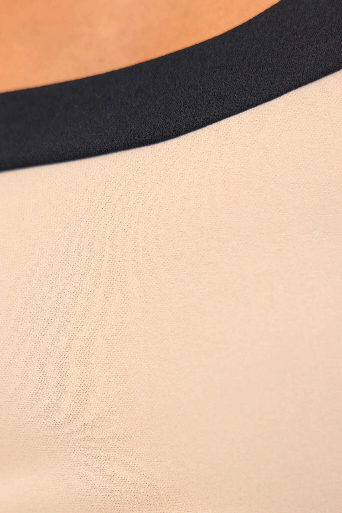 Close-up of the neckline of a City Lights Maxi Dress featuring contrasting colors of beige and black.