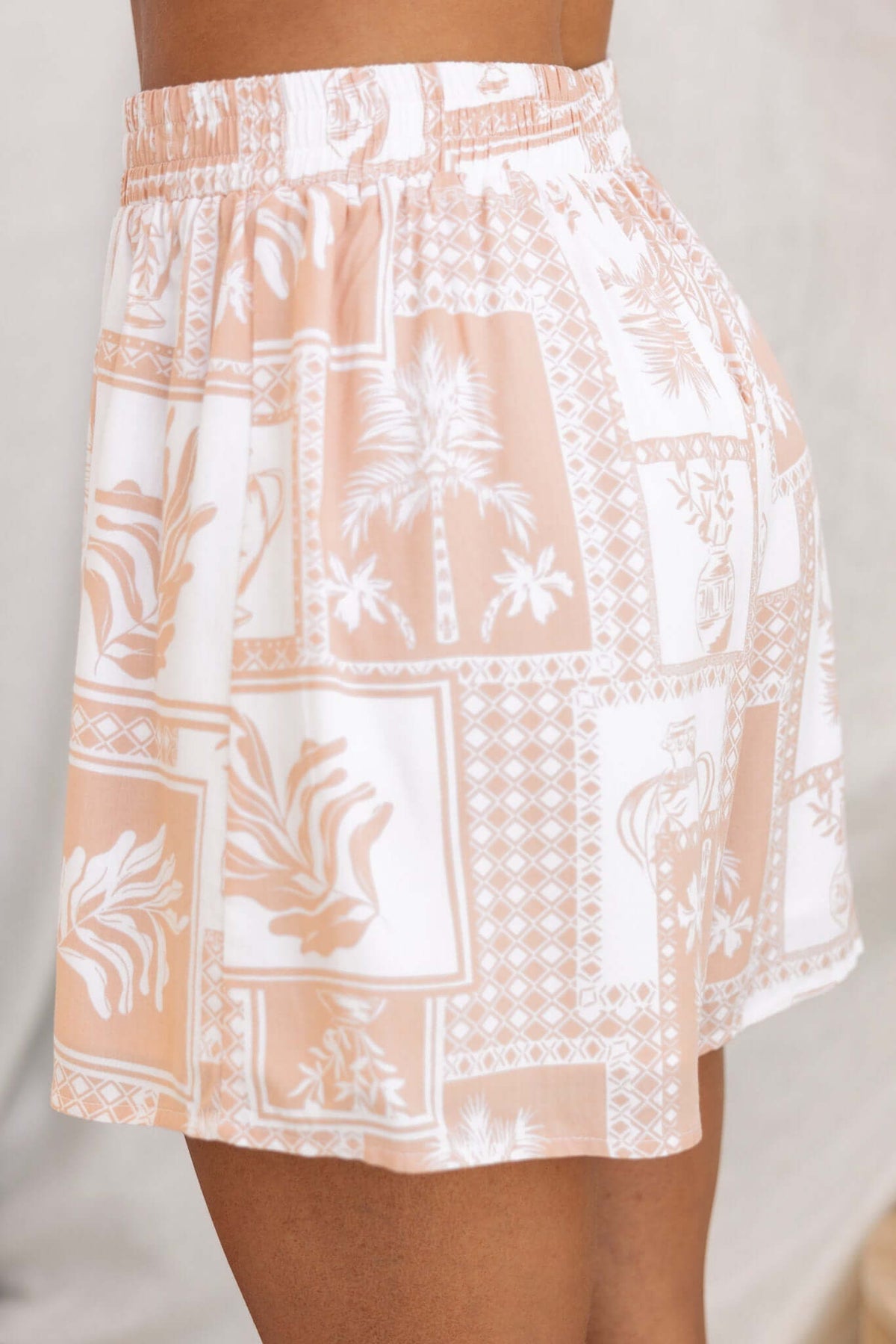 Lazy Sunday Shorts in a light peach print with palm designs, featuring an elastic waistband and comfortable fit.