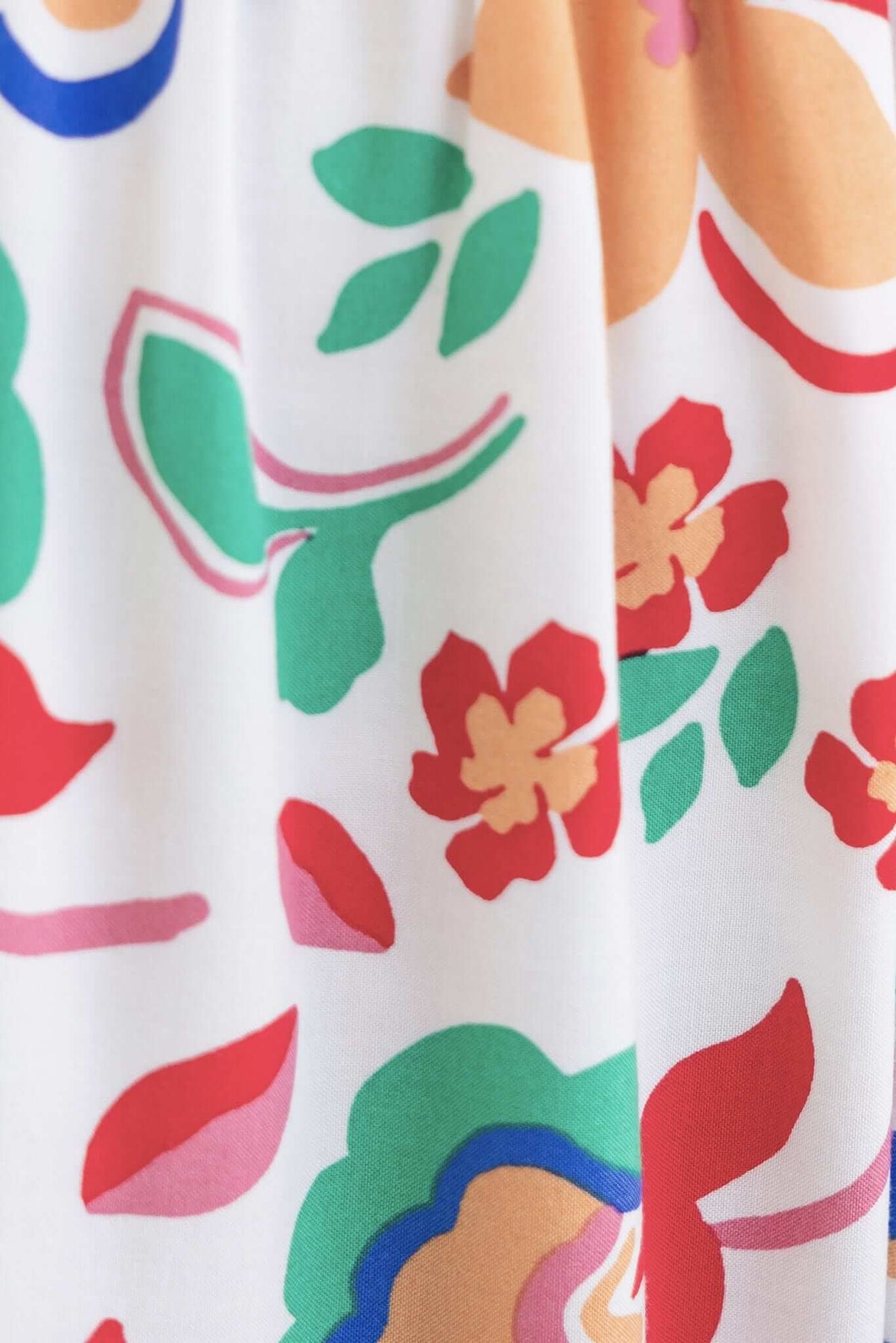 Colorful floral print close-up on the Skipper Midi Dress, showcasing vibrant designs in red, green, and orange hues.