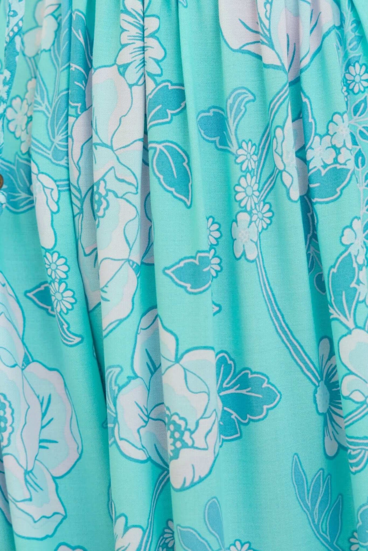 Close-up of floral pattern on Coastal Breeze Maxi Dress in turquoise and white hues.
