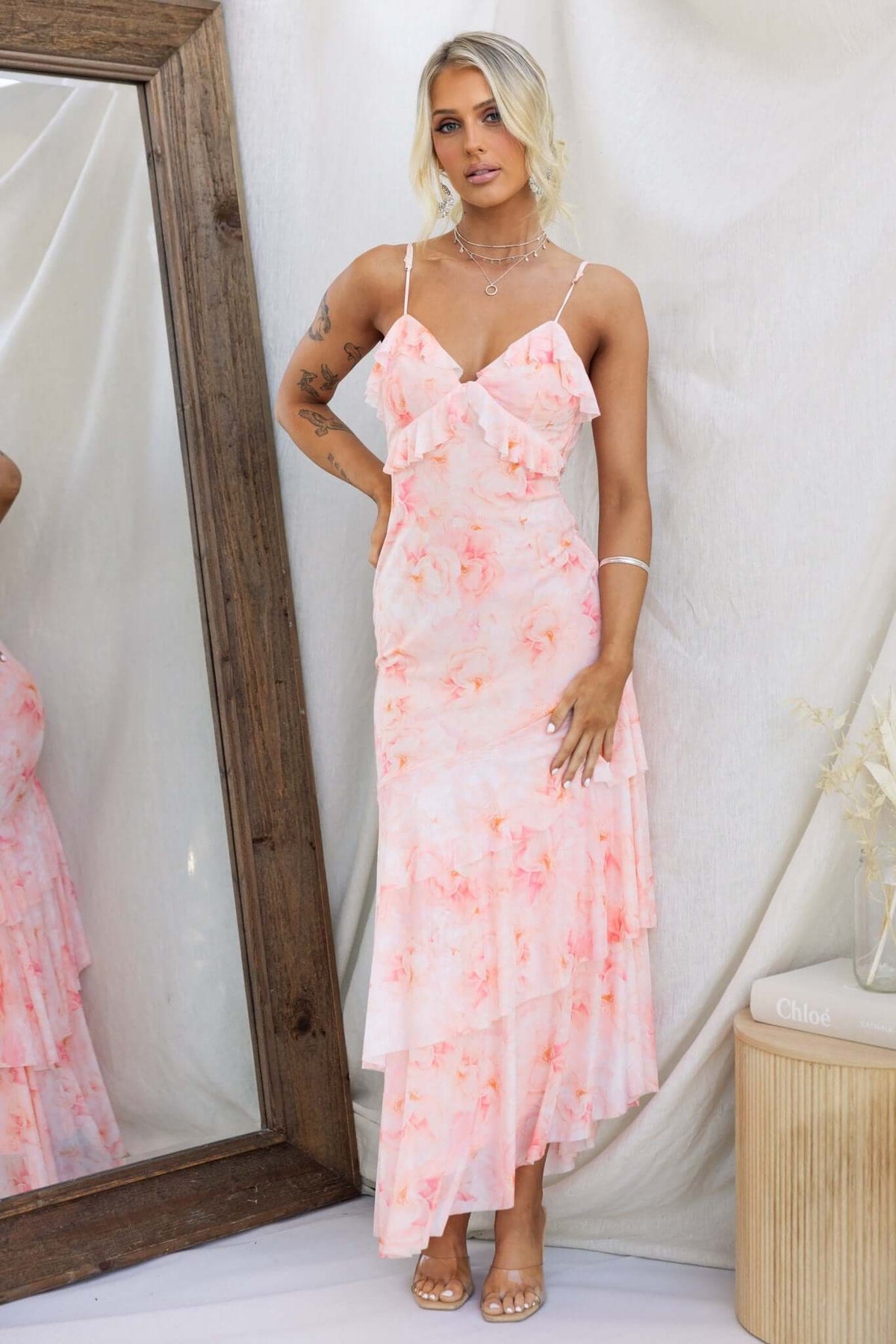 Vessy Maxi Dress featuring adjustable spaghetti straps, asymmetrical hemline, and floral mesh fabric in pink tones.