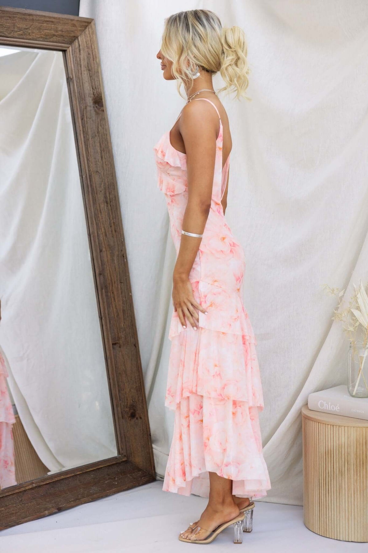 Model showcasing the Vessy Maxi Dress with adjustable straps, featuring a tiered design and asymmetrical hemline in a soft floral print.