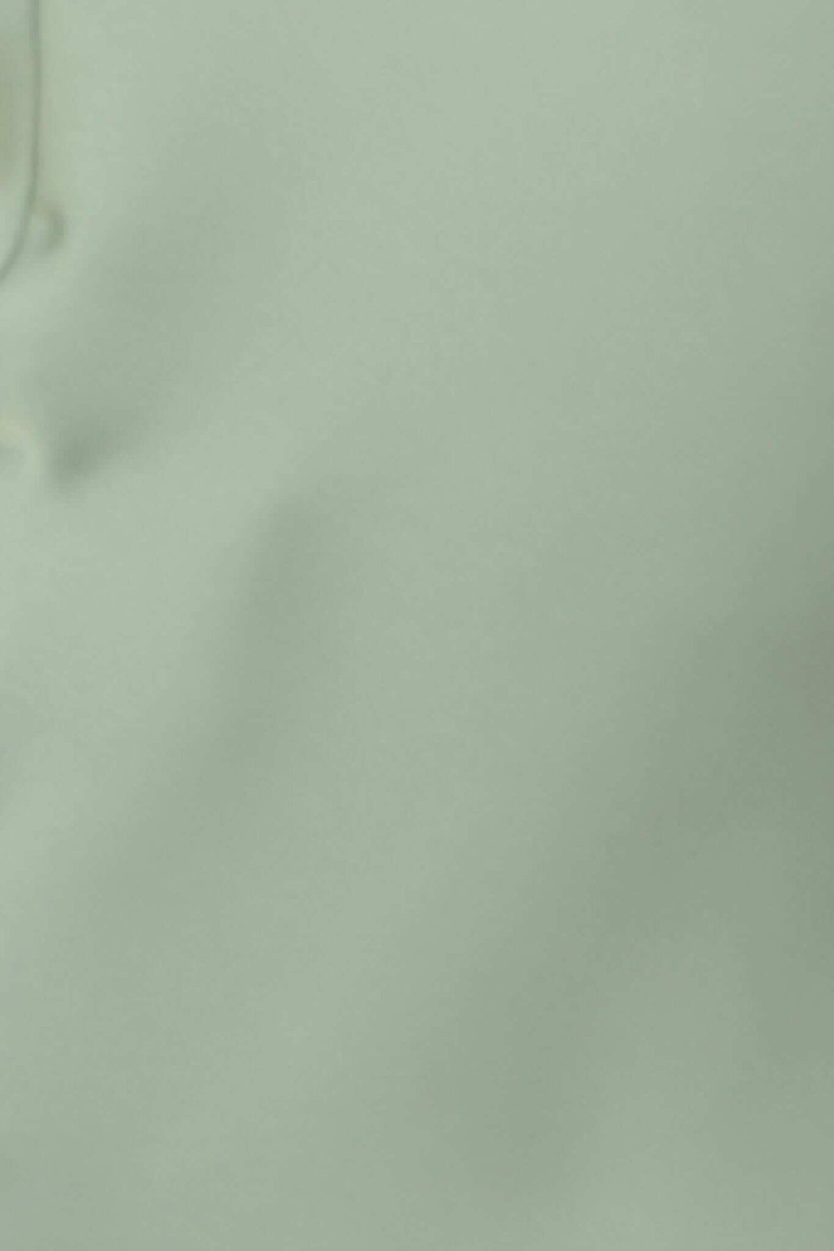 Close-up of soft, satin-feel fabric in pale green, showcasing its smooth texture and weight for a stylish mini dress.