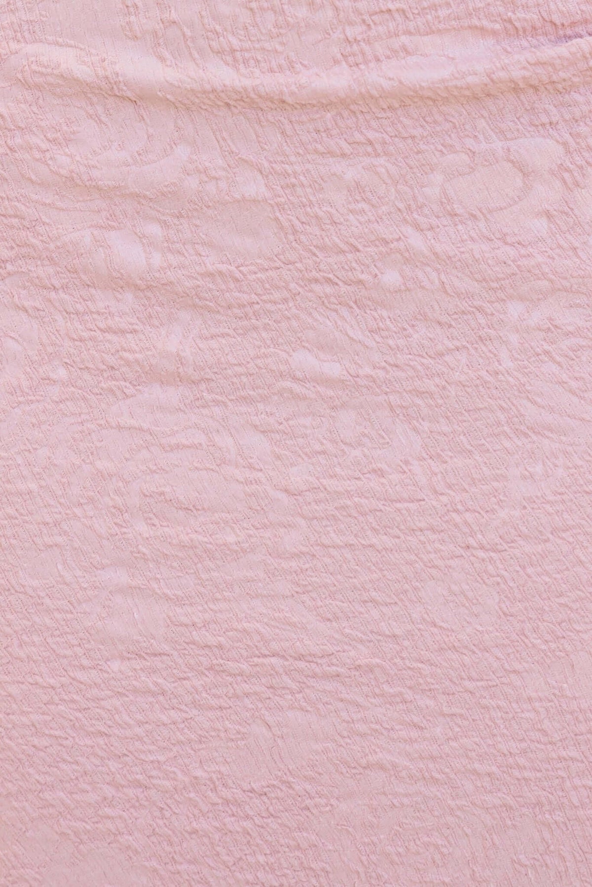 Textured close-up of the blush pink fabric of the Sheridan Midi Dress, featuring a soft and stretchy material.