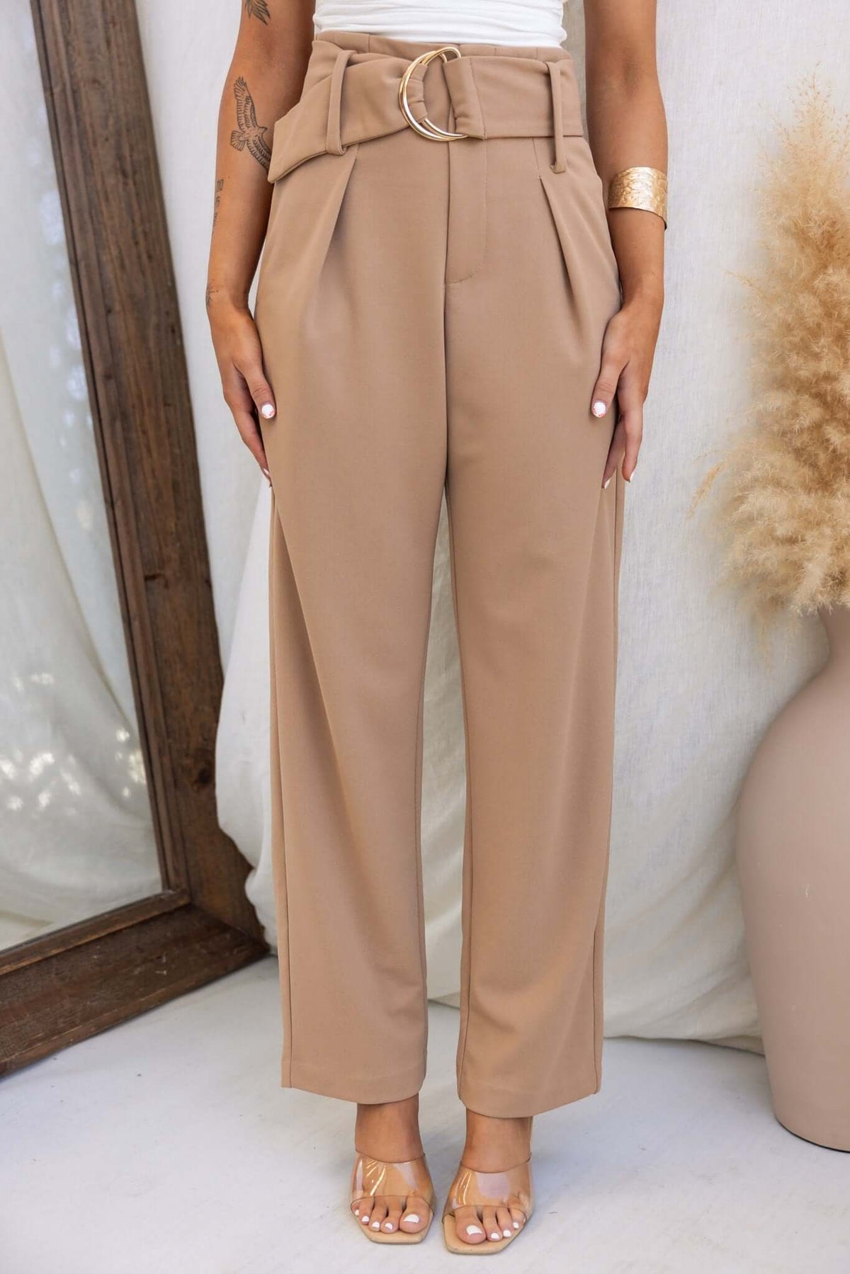 Huffington Pants in beige, featuring high waist, removable belt, pockets, and relaxed fit. Perfect for a stylish look.