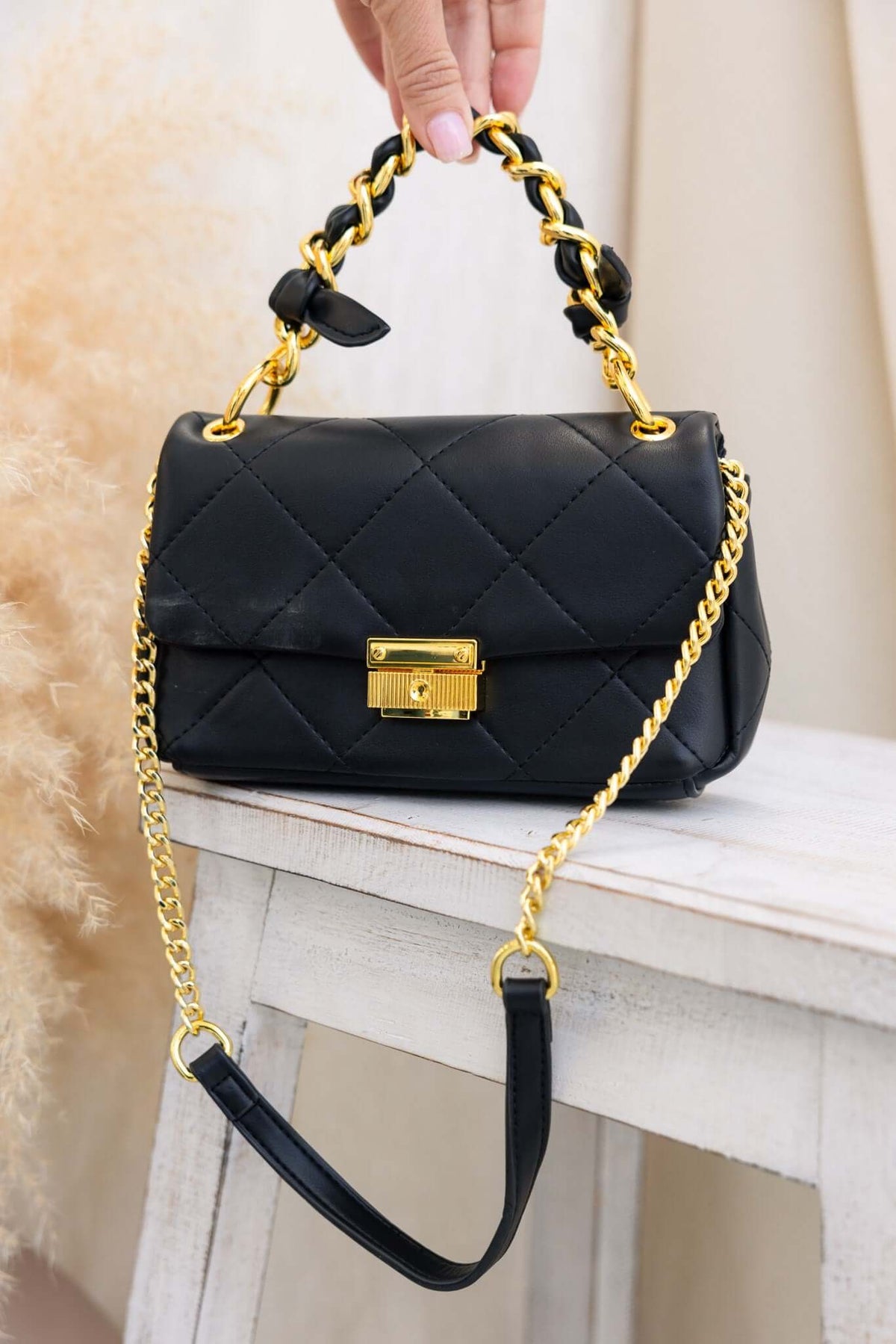 Stylish Ari Bag with chunky handle and gold chain, featuring vegan leather and a gold clasp, perfect for any occasion.