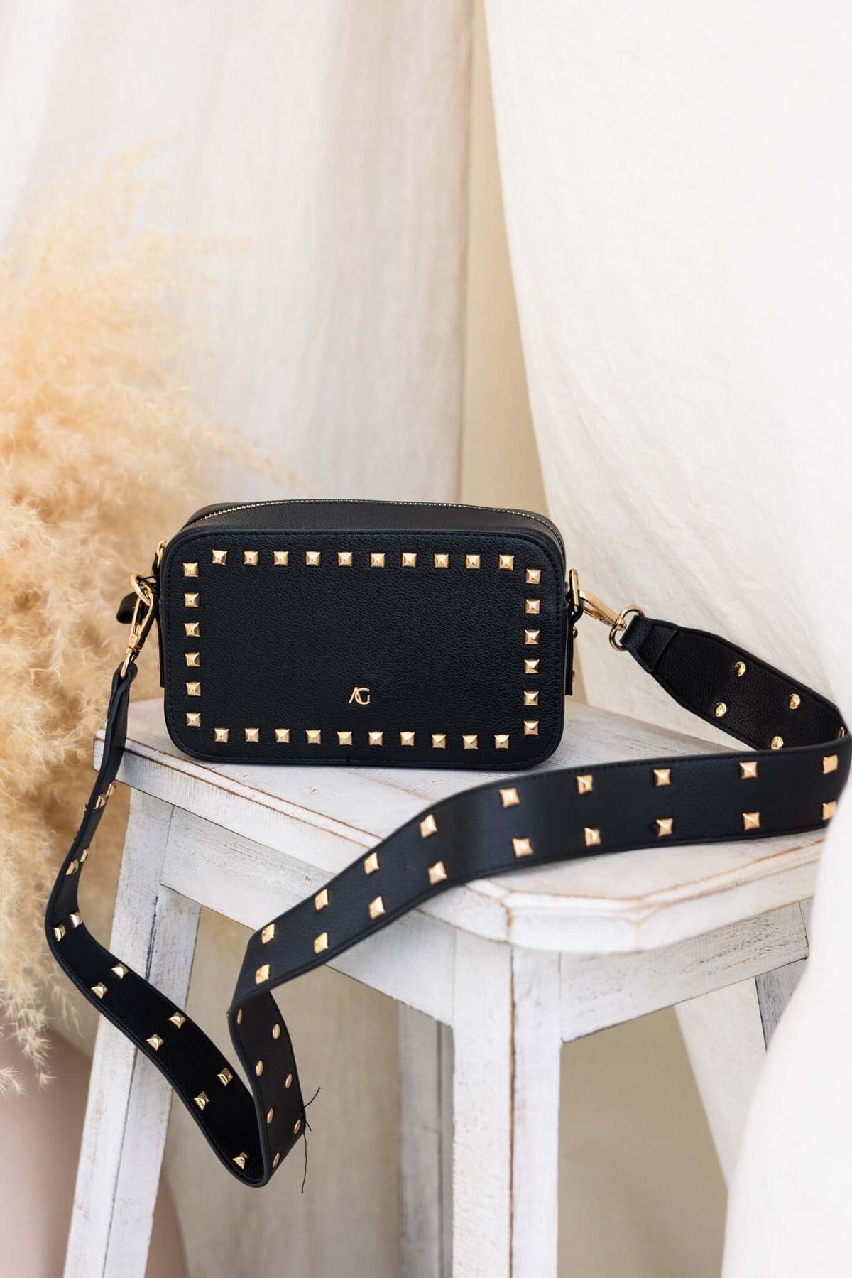 Veronica Crossbody Bag in black with metallic studs, featuring adjustable strap, stylish and compact for essentials.