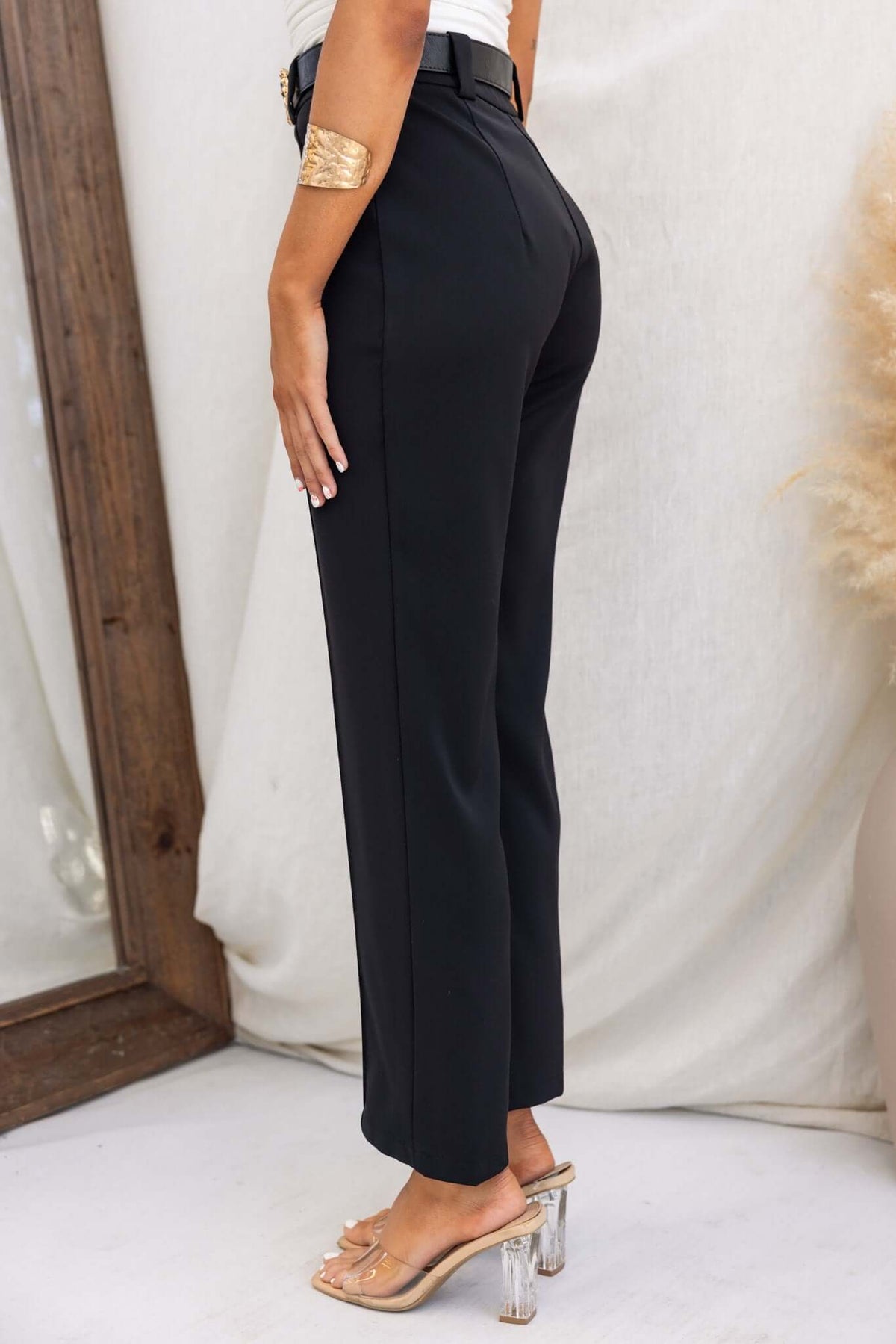 Columbus Pants in black, featuring a mid-high waist fit, non-stretch fabric, styled with clear heels.