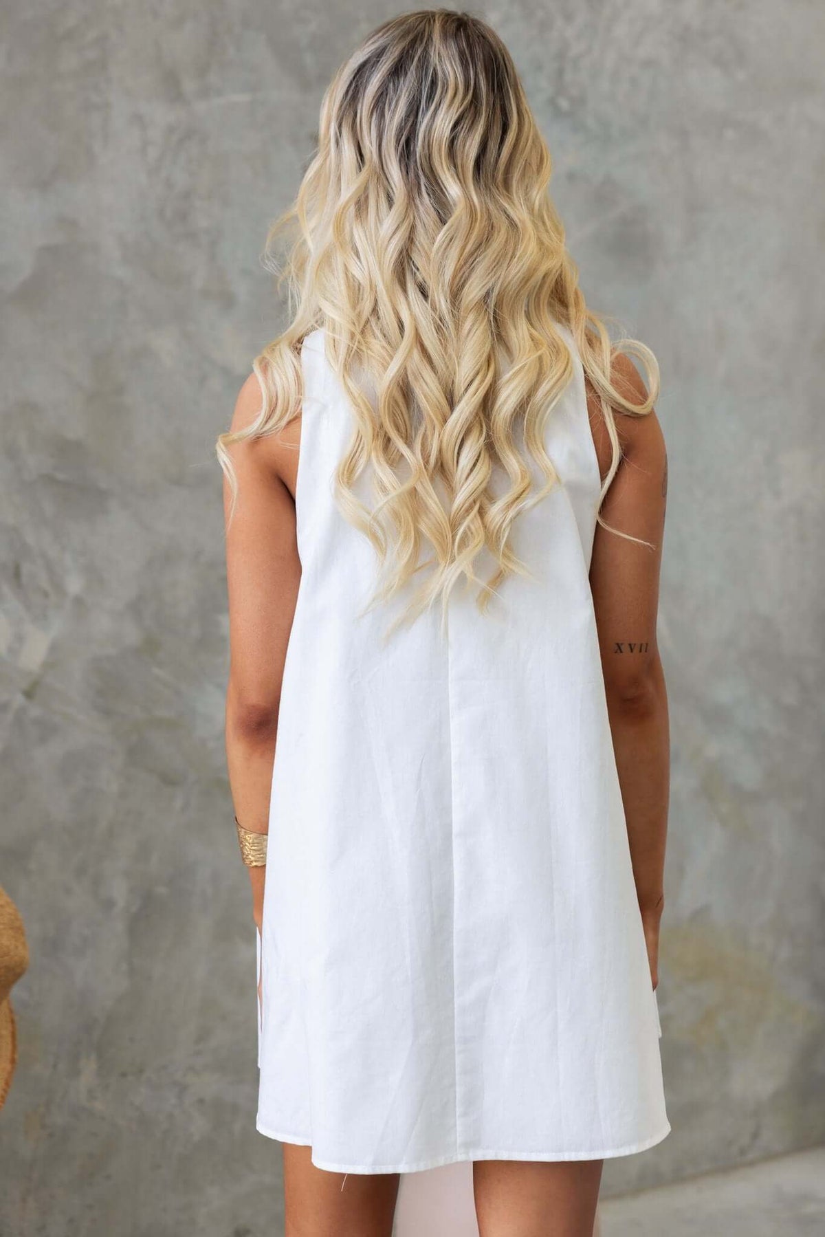Model showcasing the back of a Sandy Day Dress, a relaxed fit summer dress with an A-line style.