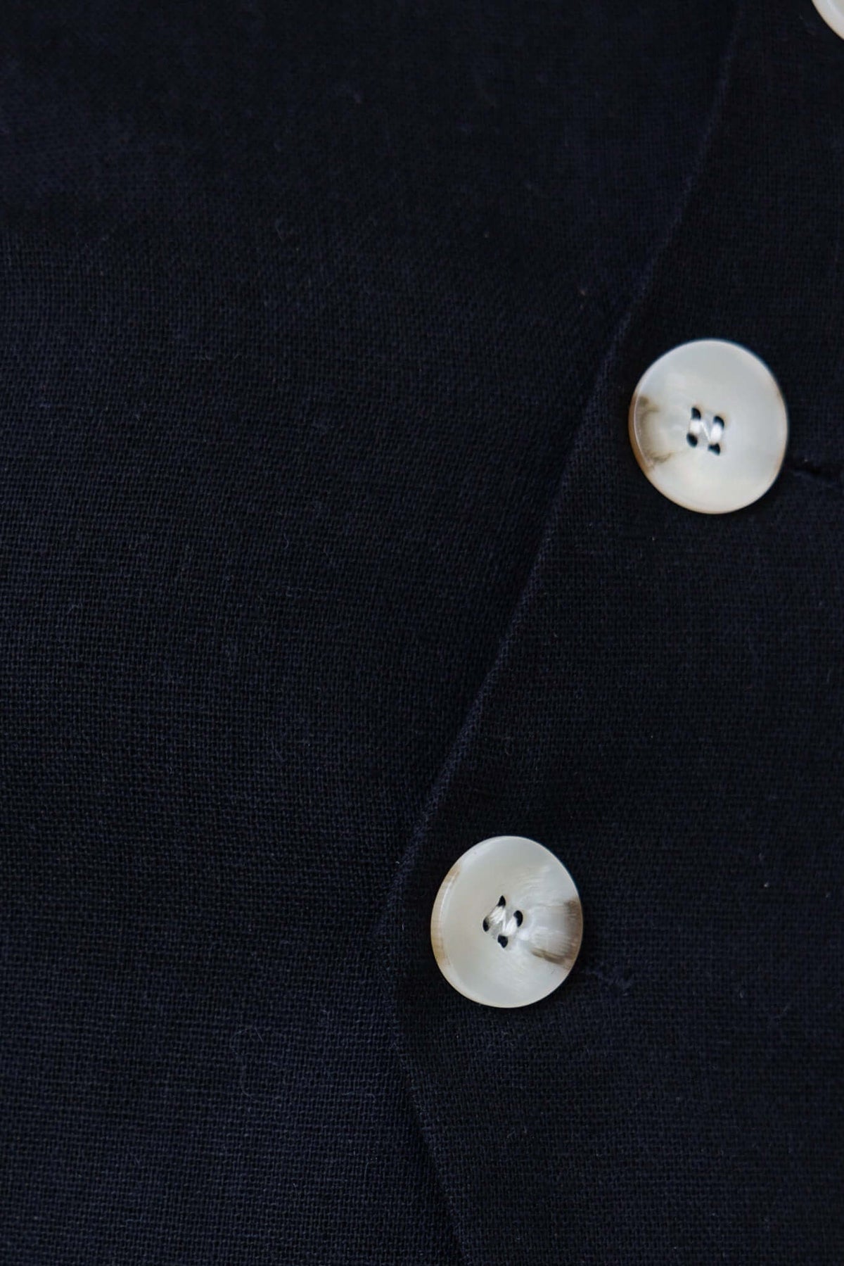 Close-up of black Payson Top showcasing stylish button detail and linen-like texture.