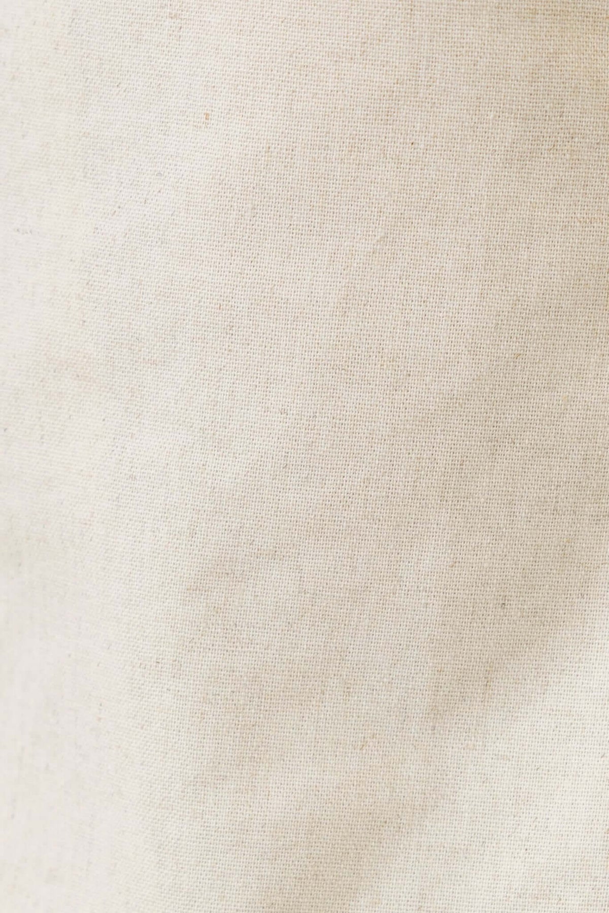 Close-up of a soft, natural linen fabric in a beige hue, perfect for stylish tops and breathable wear.