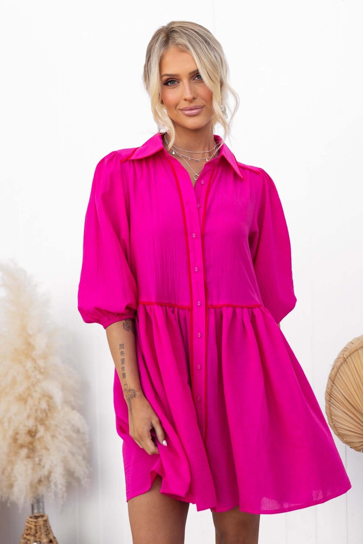 Model wearing a vibrant pink Sherbet Dress with a button-down front and oversized fit, styled for a casual look.