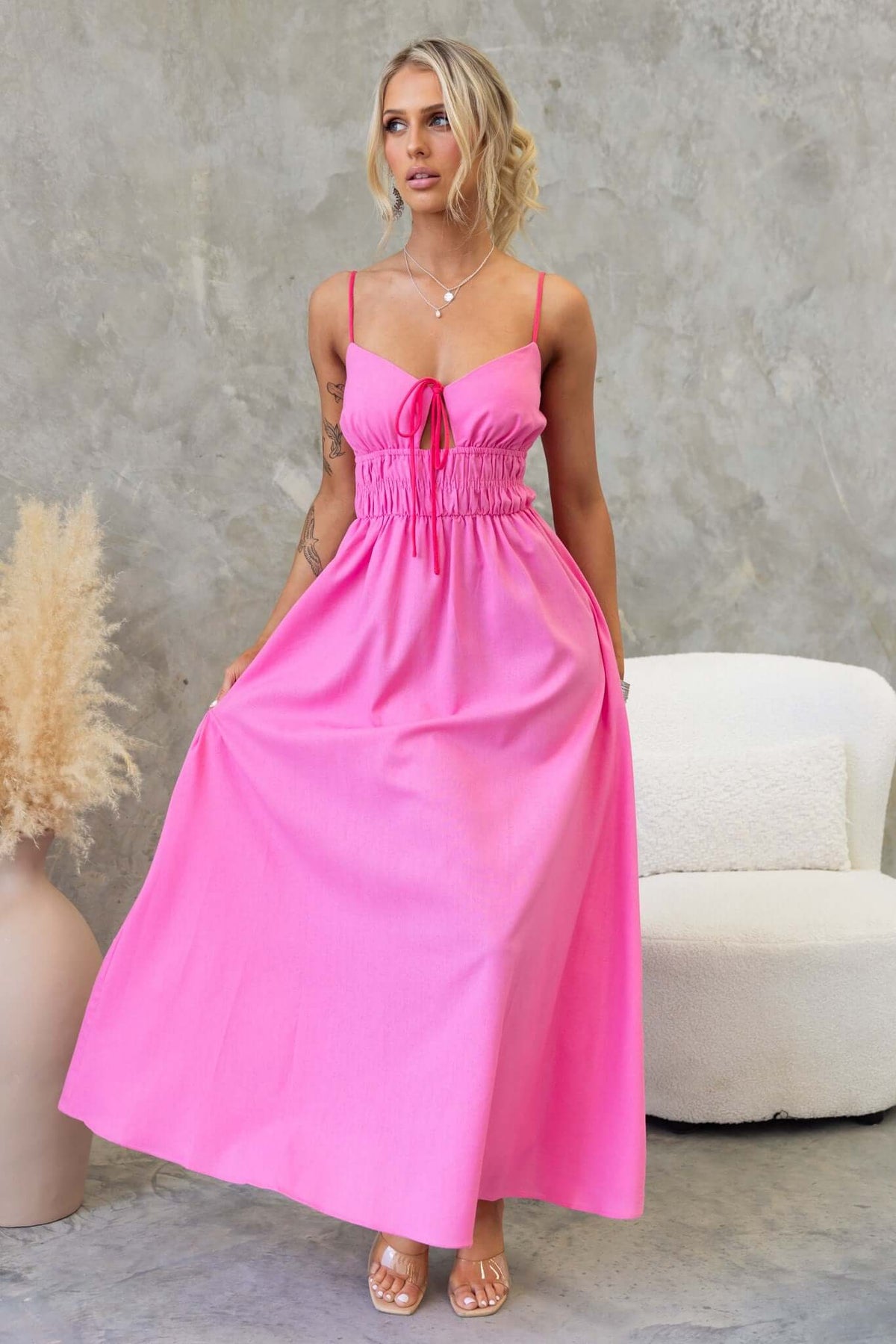 Brooklynn Maxi Dress in vibrant pink with adjustable straps, tie detail, and elastic waist for stylish summer wear.