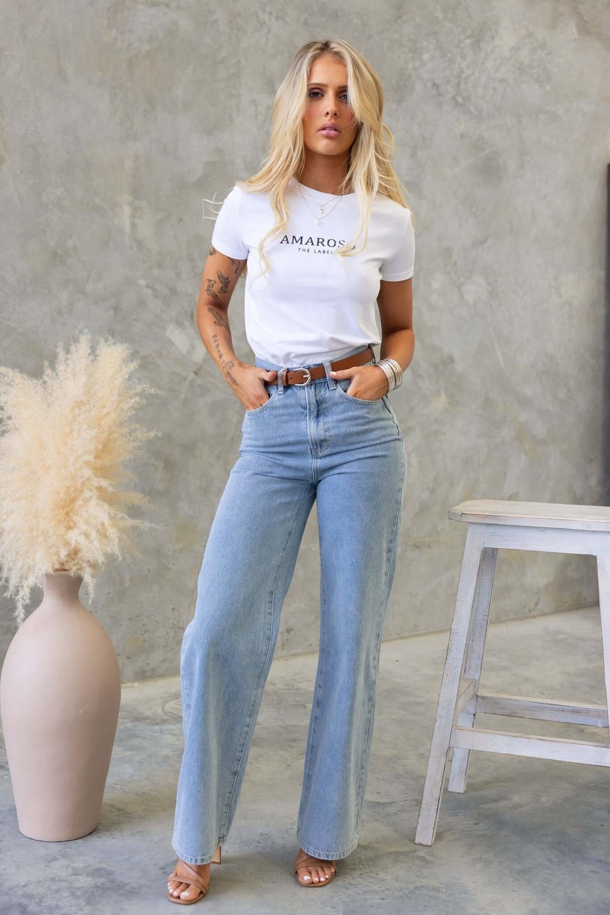 Model wearing Claremont Jeans: high waist, wide leg denim styled with a graphic t-shirt and sandals.