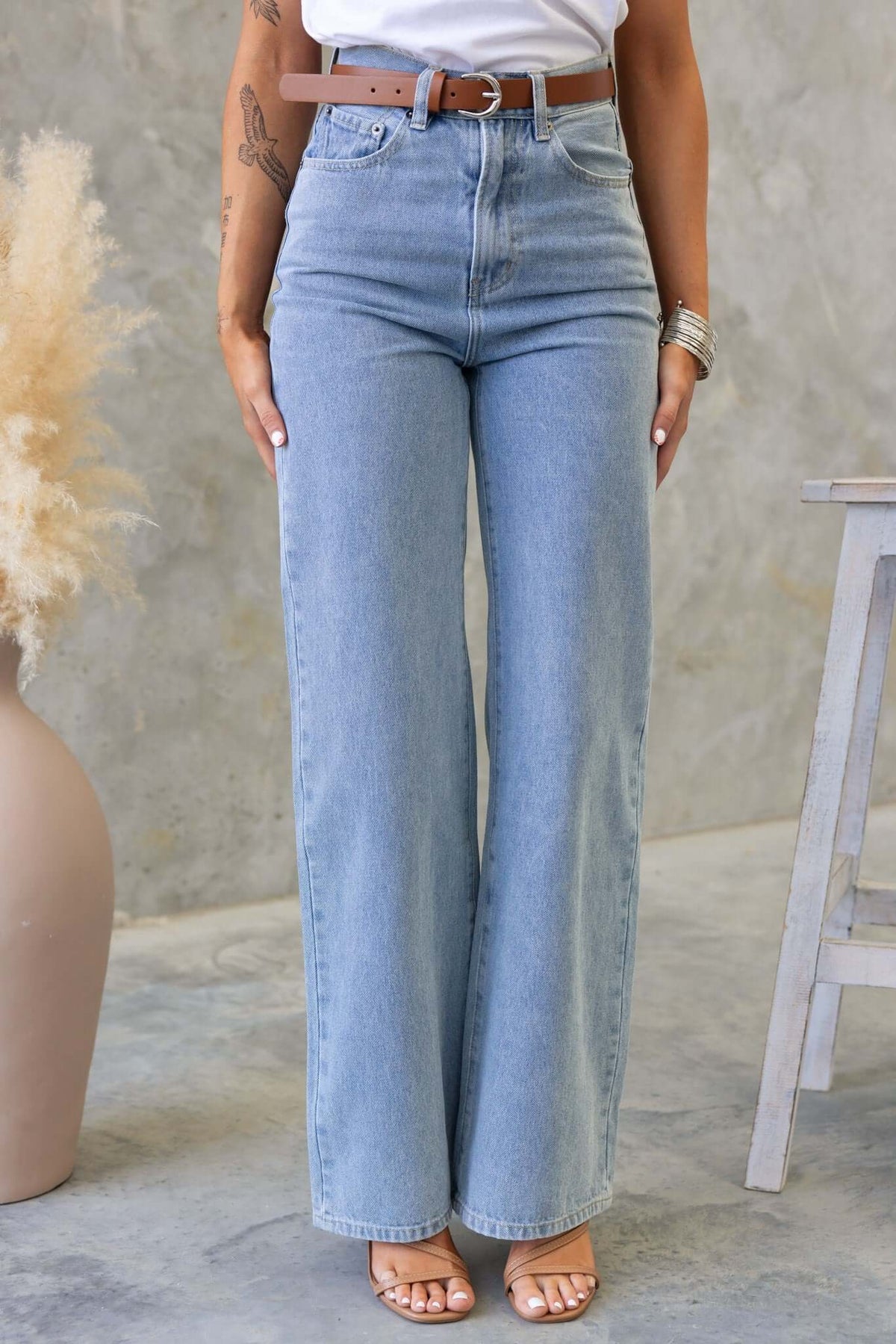 Claremont Jeans in high waist fit with wide straight legs, styled with a brown belt on a model.