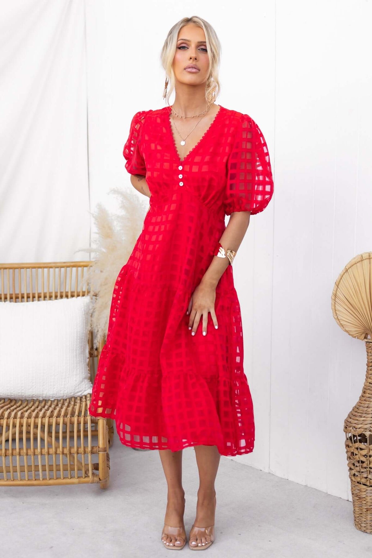 Barker Midi Dress in red with faux button front, puff sleeves, and elastic waist, styled in a natural setting.