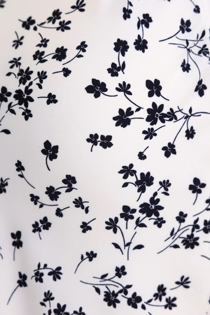 Floral print pattern featuring small black flowers on a white background, ideal for summer dresses.