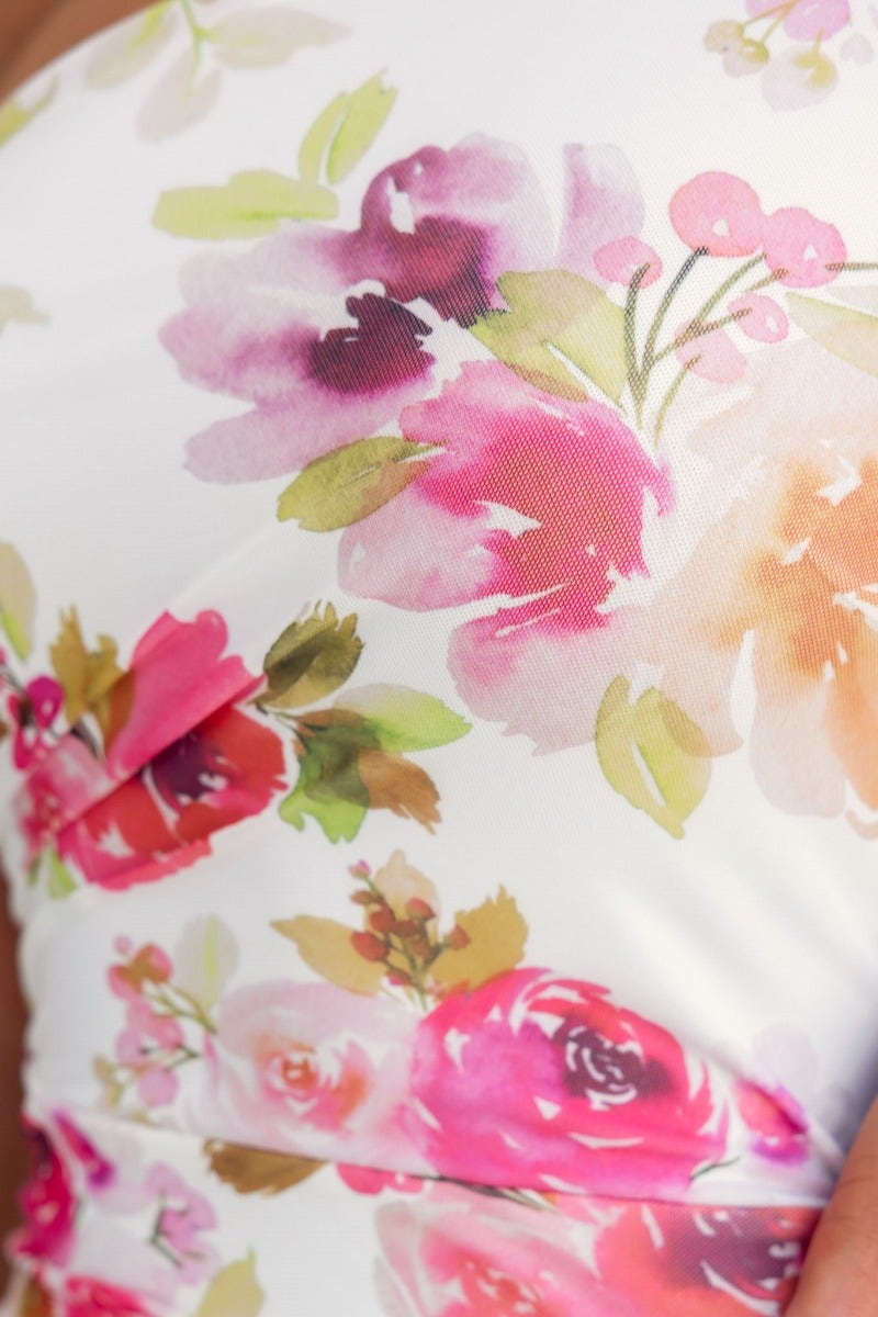 Close-up of floral pattern on Stolen Kiss Maxi Dress featuring pink and coral roses on a white background.
