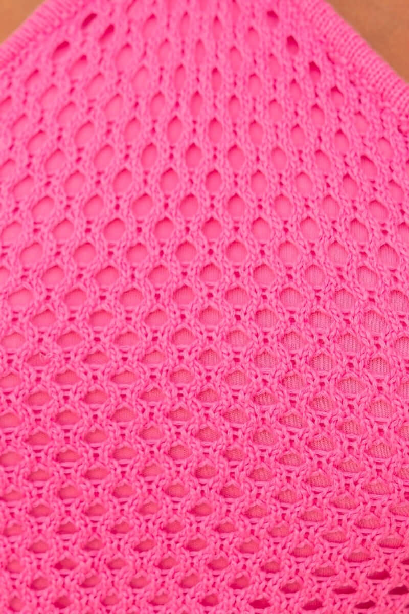 Close-up of the crochet pattern on a vibrant pink Catani midi dress, showcasing its intricate texture and design.