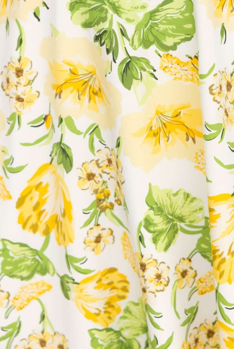 Floral print design featuring yellow and green flowers on a white background for the Desired Midi Dress.