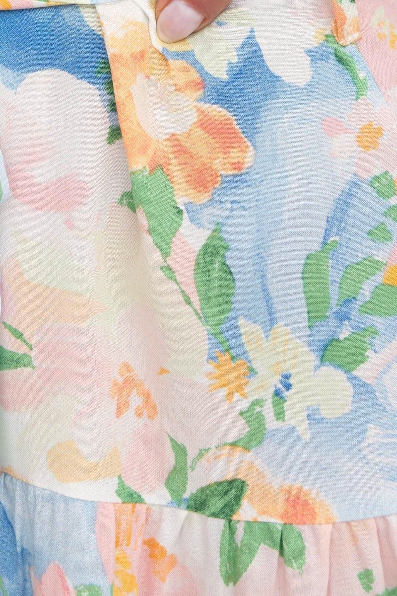 Close-up of floral print fabric in pastel colors featuring vibrant blooms and a soft texture.