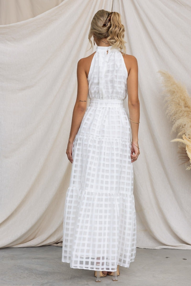 Back view of white Aspiring Maxi Dress with high neckline, elastic waistband, and removable belt, styled against a neutral backdrop.