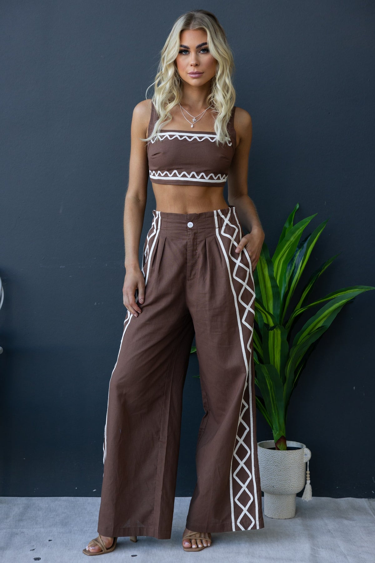 Drisko Set featuring a square neckline crop top and high-waisted wide-leg pants with side pockets and embroidered details.
