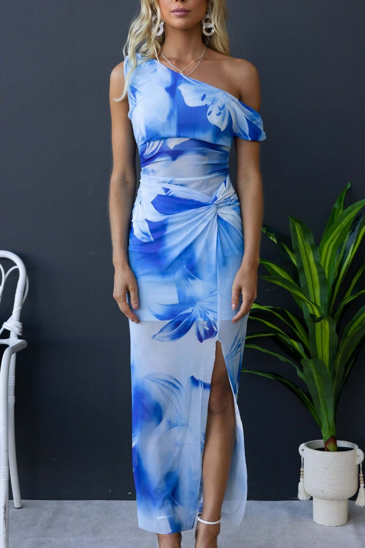 Escala Maxi Dress featuring asymmetric neckline, knot detail, and floral print in blue tones, perfect for elegant occasions.