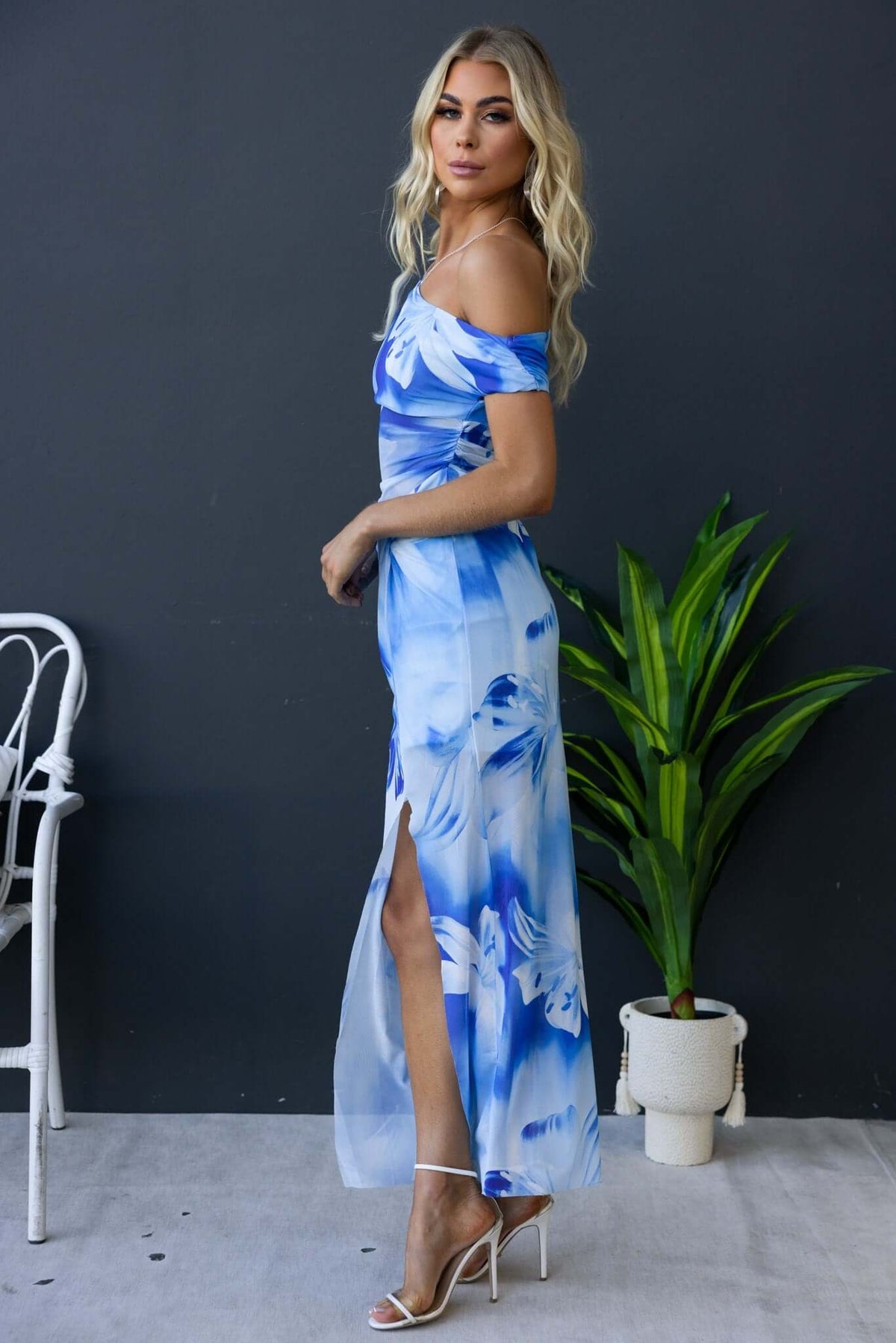 Model wearing the Escala Maxi Dress, showcasing blue floral design, front split, and off-shoulder style.