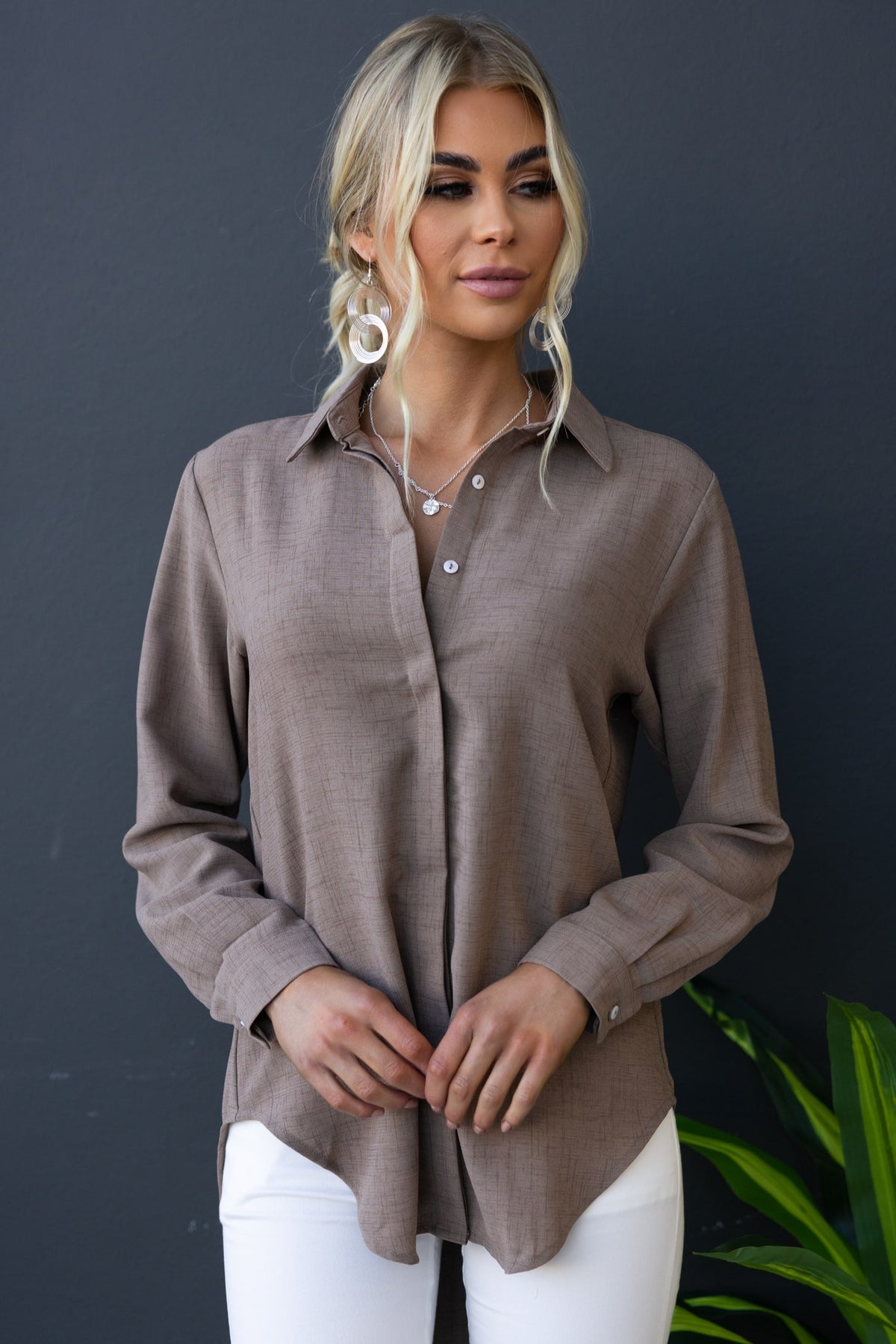 Toomba Shirt in brown, featuring a button-up front and collar, styled with white pants for a chic, relaxed look.