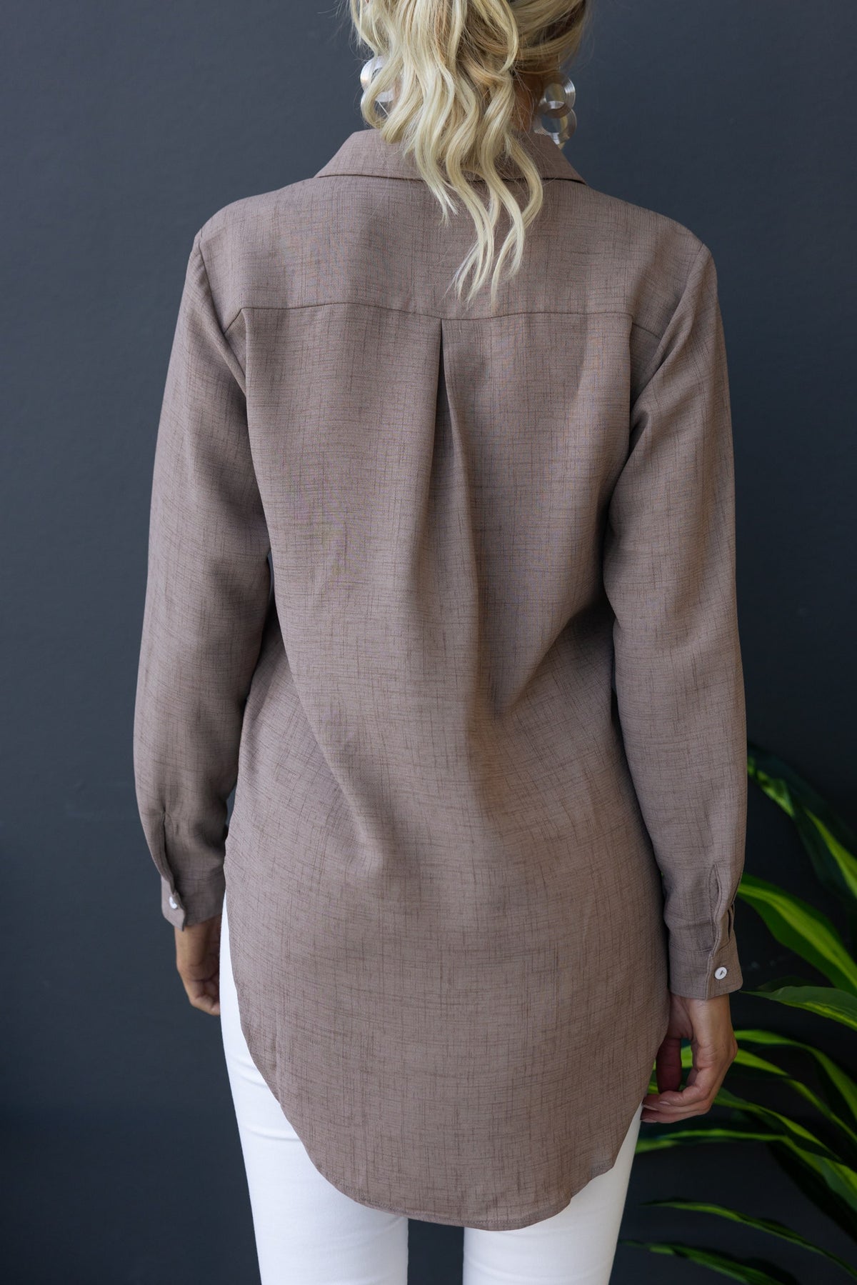 Back view of Toomba Shirt in light brown, featuring a collar and relaxed fit, styled with white pants.