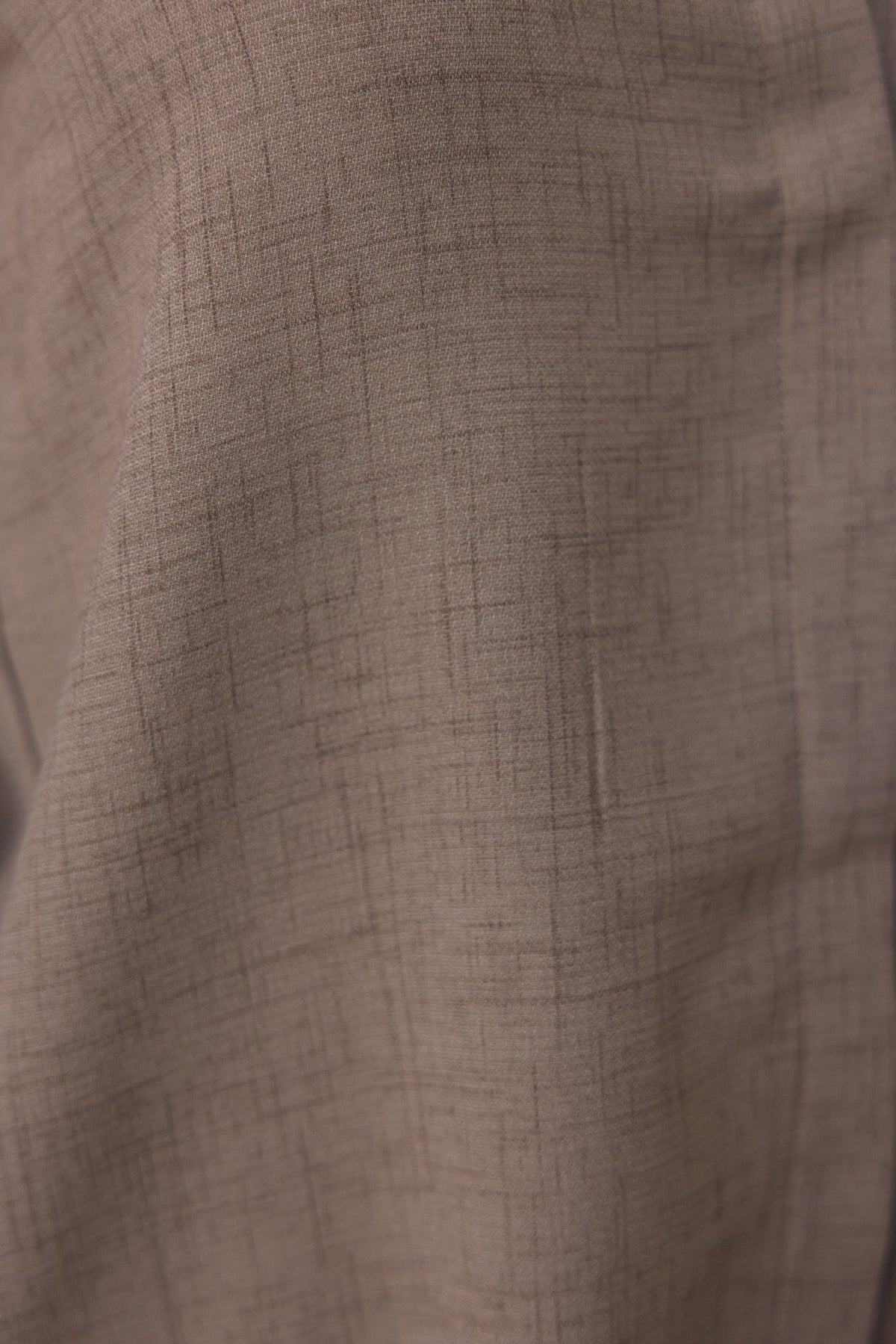 Close-up of light beige fabric texture, showcasing a subtle pattern, ideal for the Toomba Shirt.